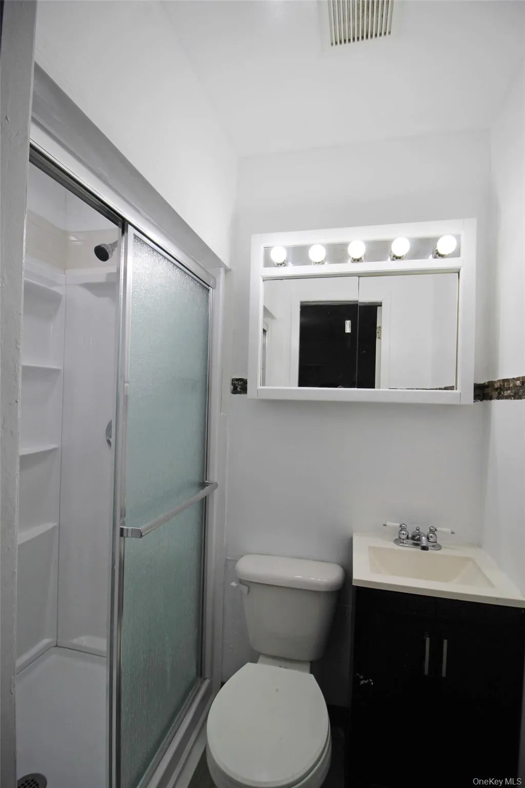 Full bathroom with a stall shower and vanity Full bathroom with a stall shower and vanity