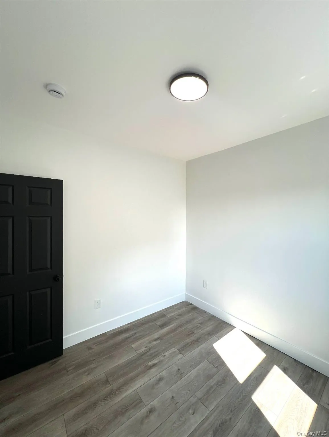 Empty room featuring baseboards and dark wood finished floors Empty room featuring baseboards and dark wood finished floors
