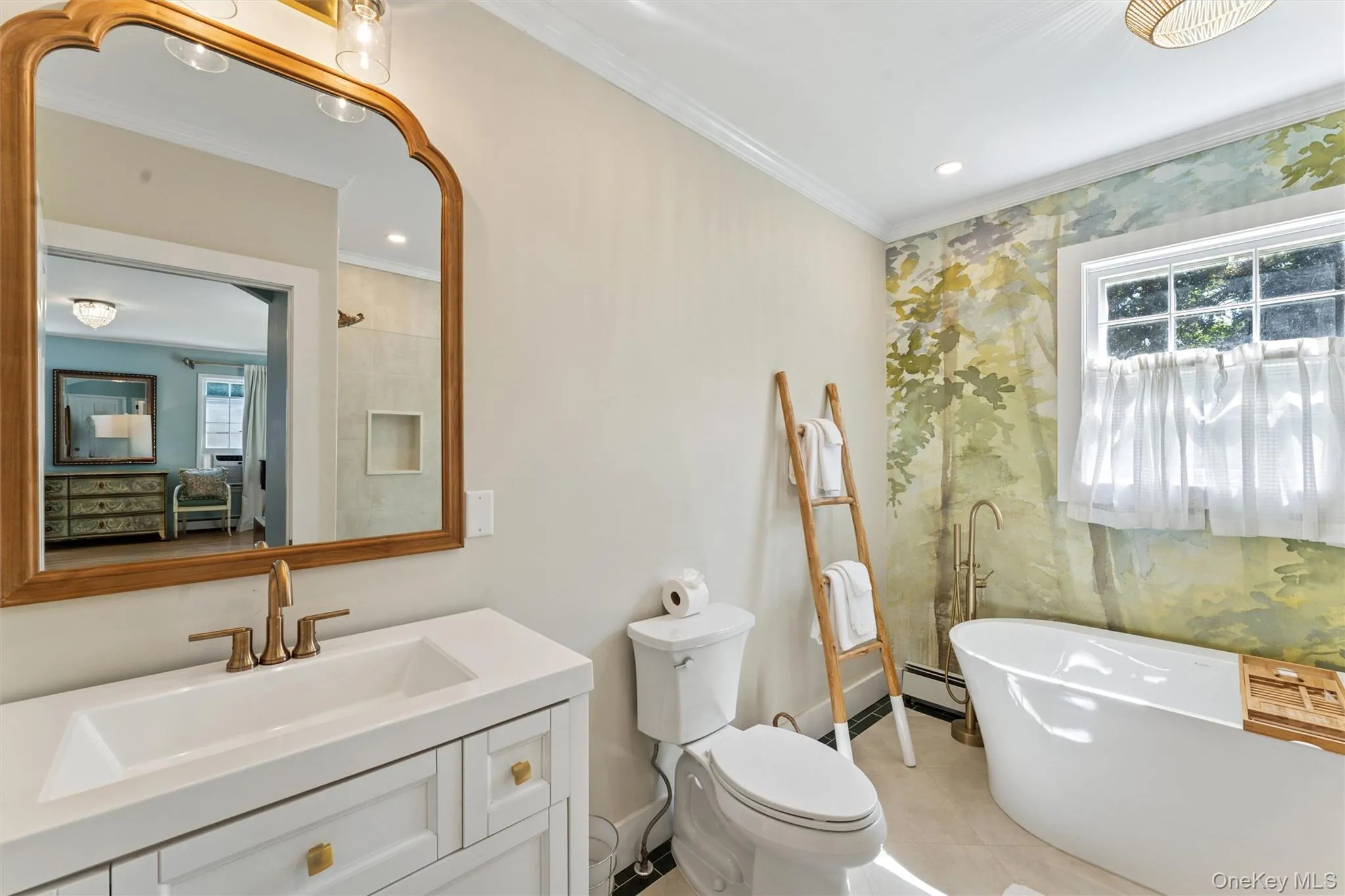 Bathroom featuring a freestanding bath, crown molding, vanity, a baseboard radiator, and light tile patterned flooring Bathroom featuring a freestanding bath, crown molding, vanity, a baseboard radiator, and light tile patterned flooring