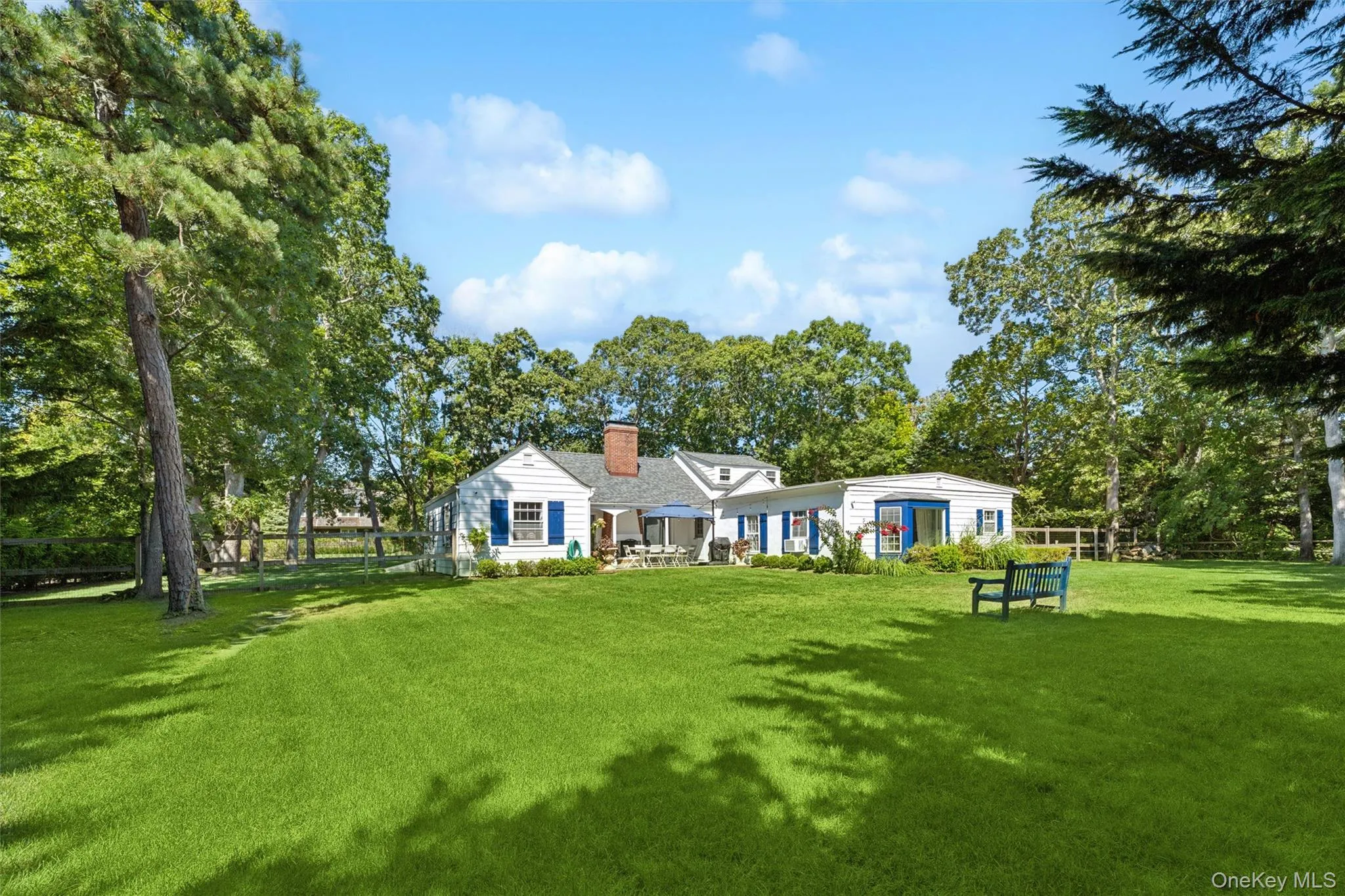 Back of house featuring a chimney and view of wooded area Back of house featuring a chimney and view of wooded area