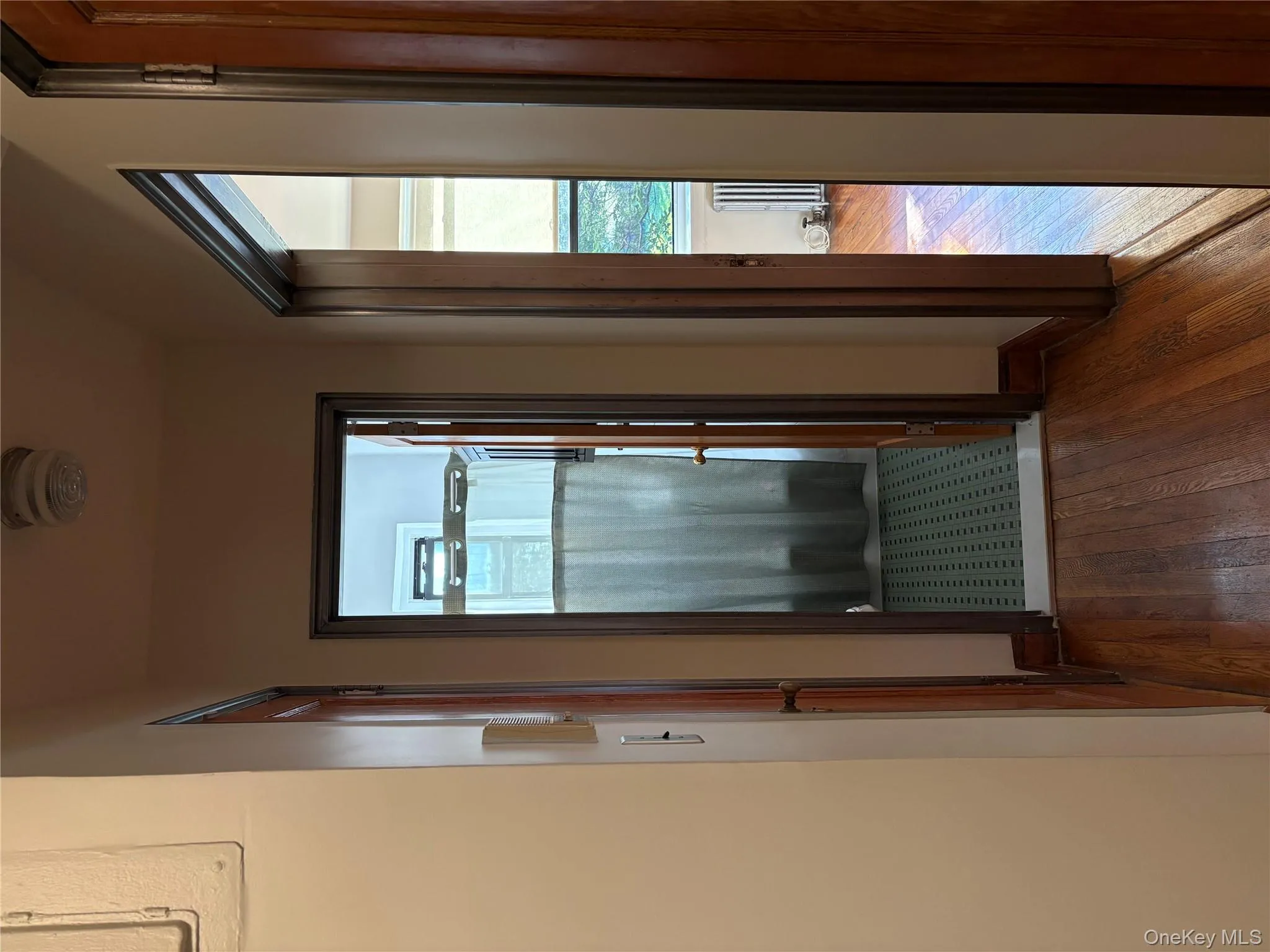 Hallway with dark wood-style flooring, healthy amount of natural light, and radiator Hallway with dark wood-style flooring, healthy amount of natural light, and radiator