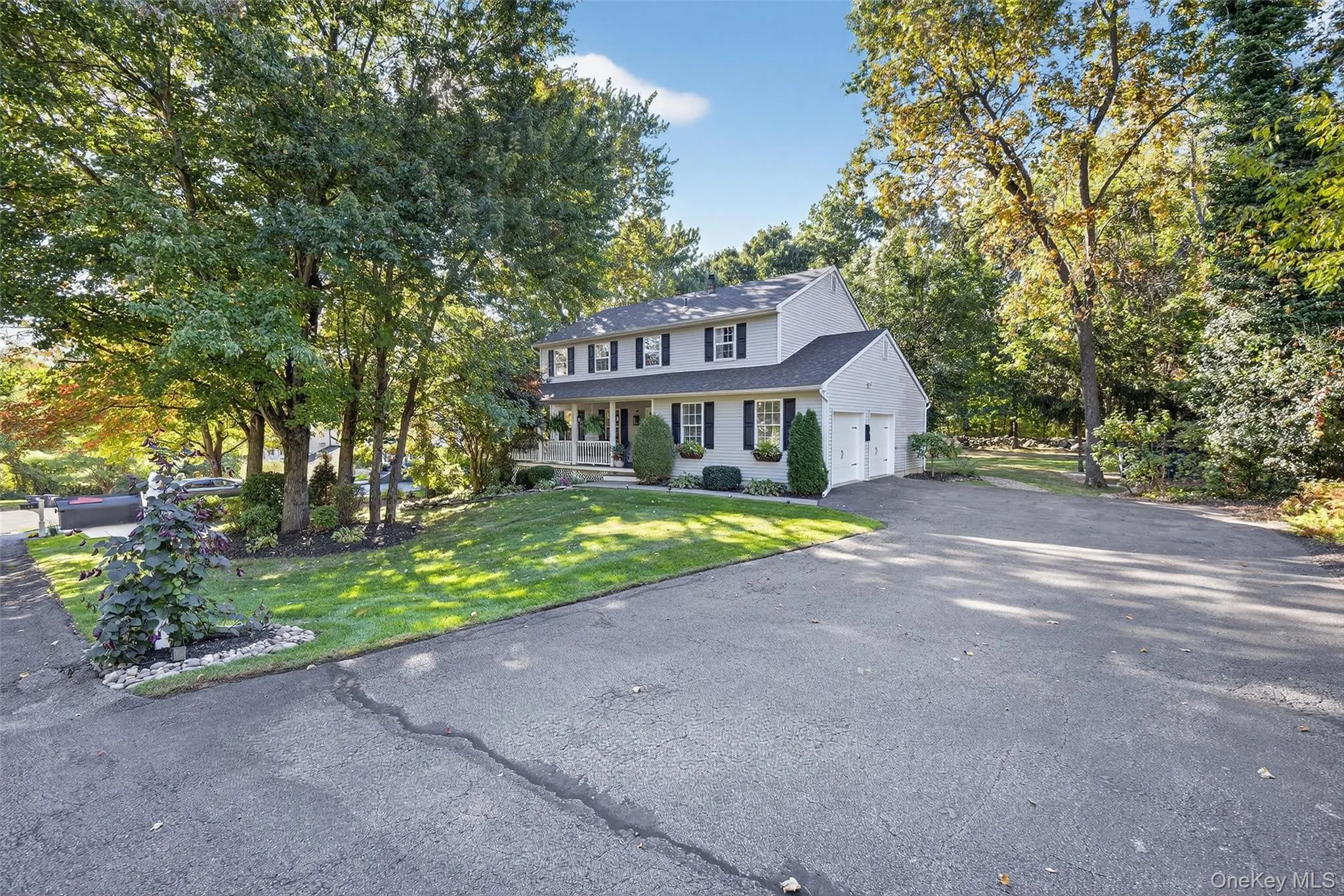 View of front of home featuring a front lawn, asphalt driveway, a garage, and covered porch View of front of home featuring a front lawn, asphalt driveway, a garage, and covered porch
