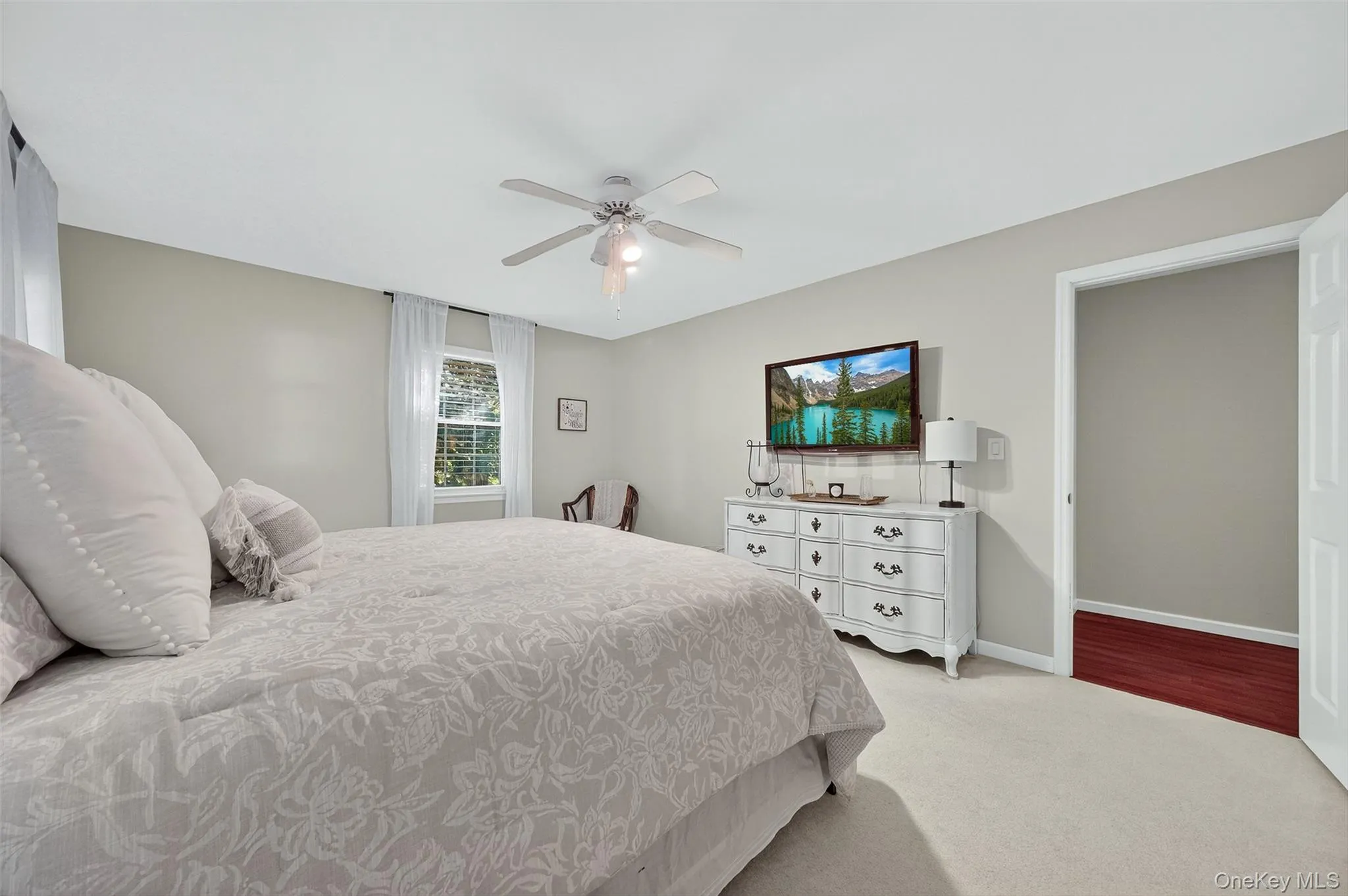 Bedroom featuring light colored carpet and ceiling fan Bedroom featuring light colored carpet and ceiling fan