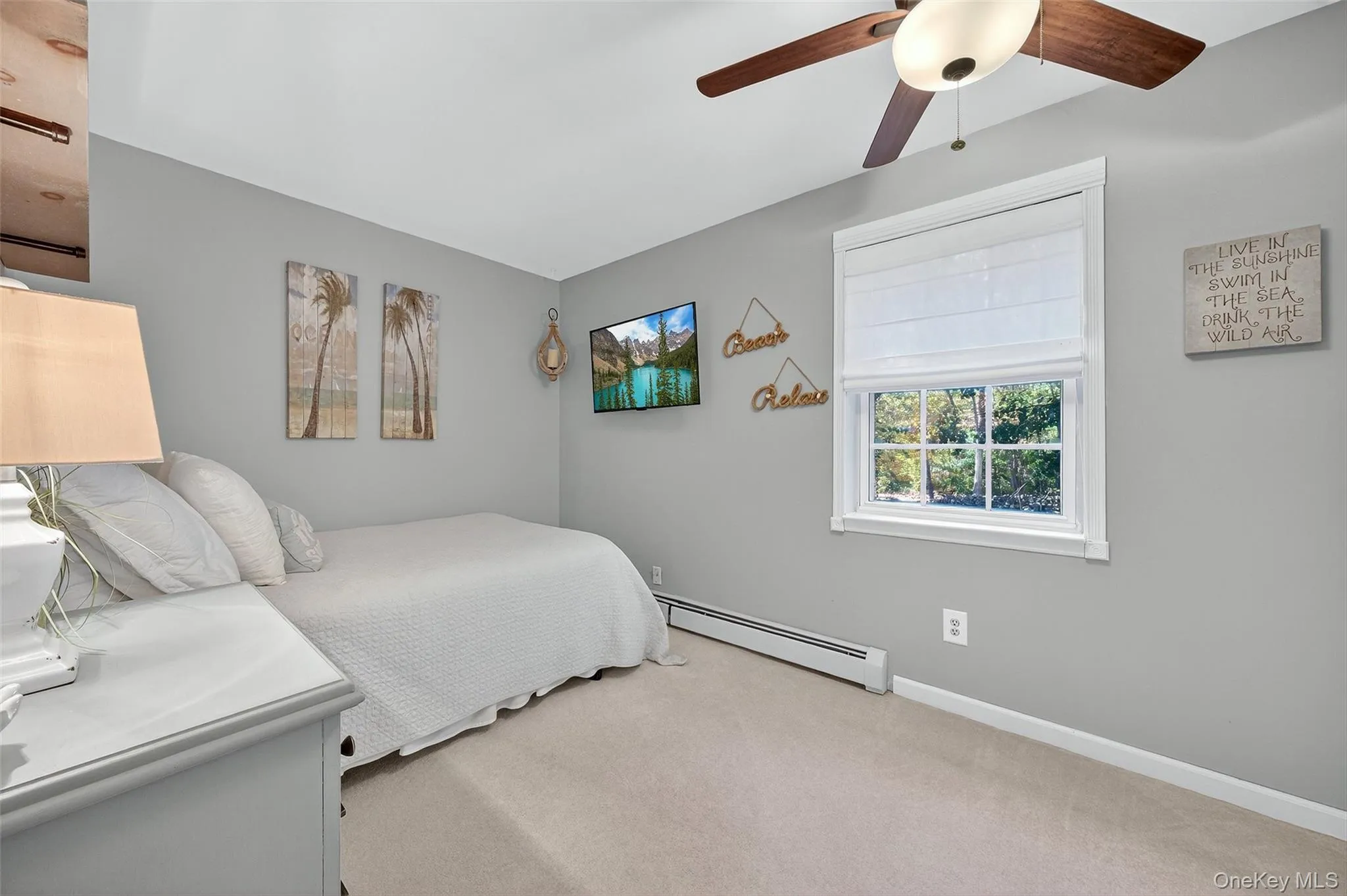 Carpeted bedroom featuring a baseboard radiator and a ceiling fan Carpeted bedroom featuring a baseboard radiator and a ceiling fan