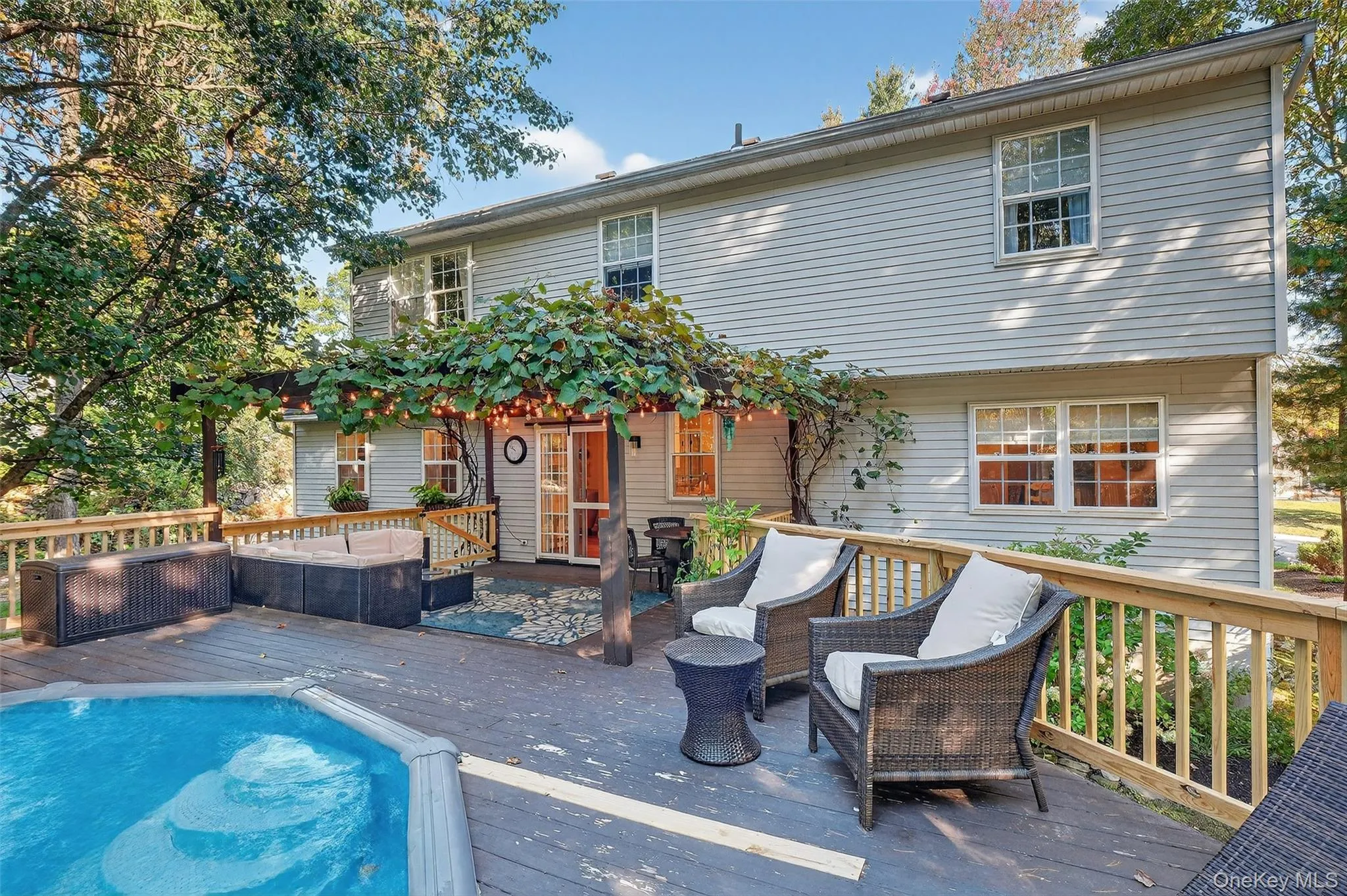 Rear view of house with a wooden deck and an outdoor hangout area Rear view of house with a wooden deck and an outdoor hangout area