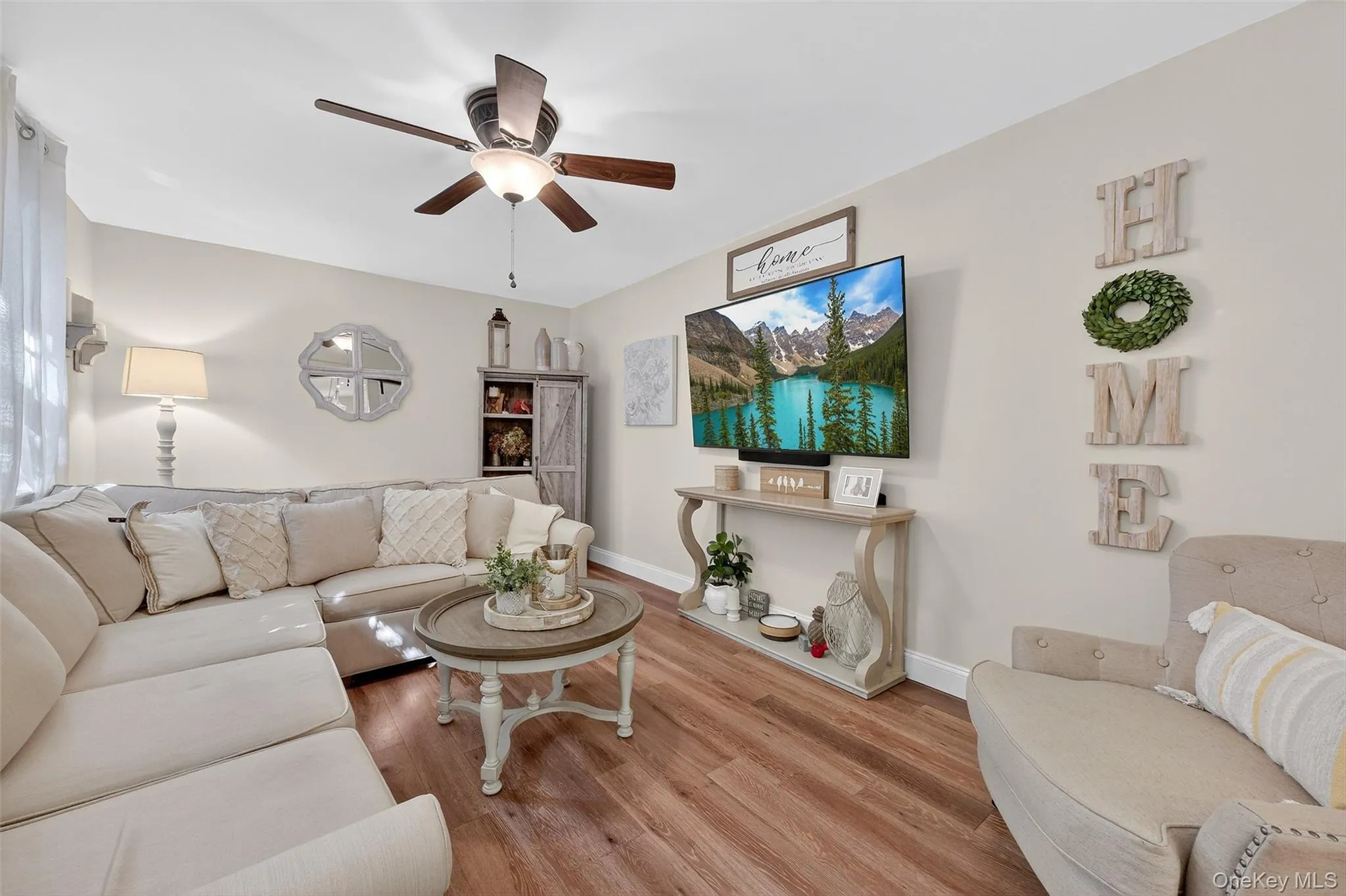 Living area with wood finished floors and a ceiling fan Living area with wood finished floors and a ceiling fan