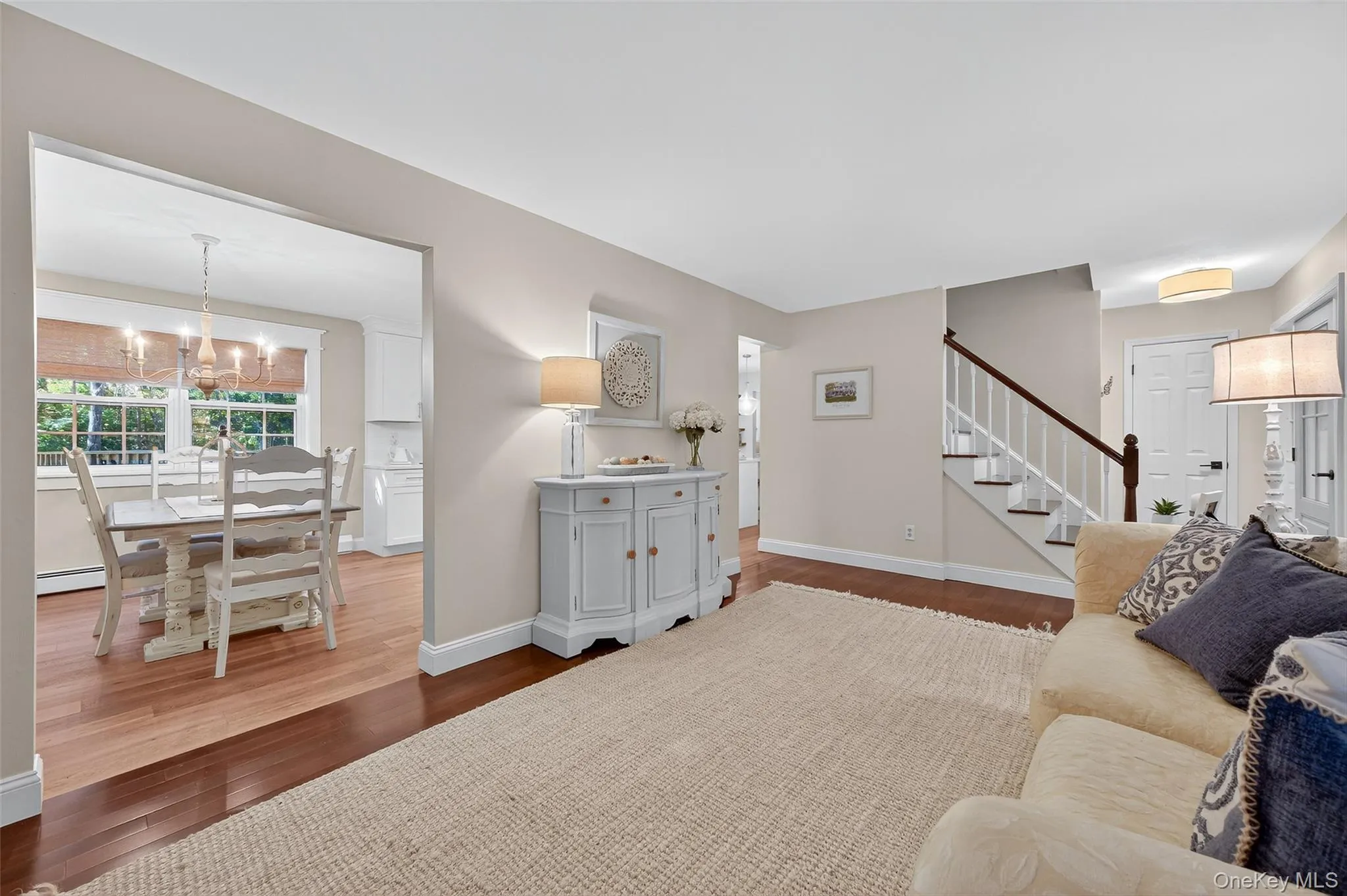 Living area with dark wood-style flooring, a chandelier, and stairway Living area with dark wood-style flooring, a chandelier, and stairway