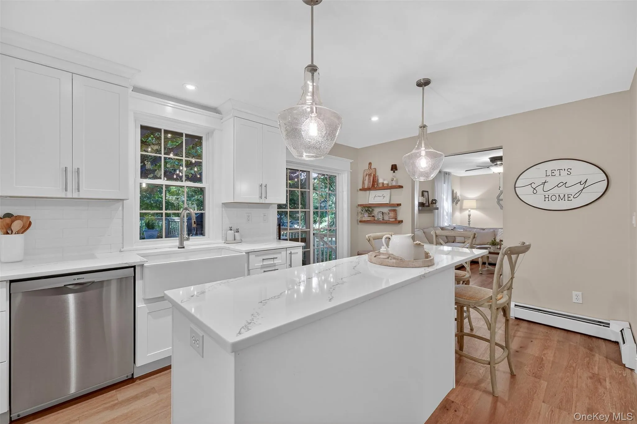 Kitchen with stainless steel dishwasher, white cabinets, light wood-style floors, a kitchen island, and recessed lighting Kitchen with stainless steel dishwasher, white cabinets, light wood-style floors, a kitchen island, and recessed lighting