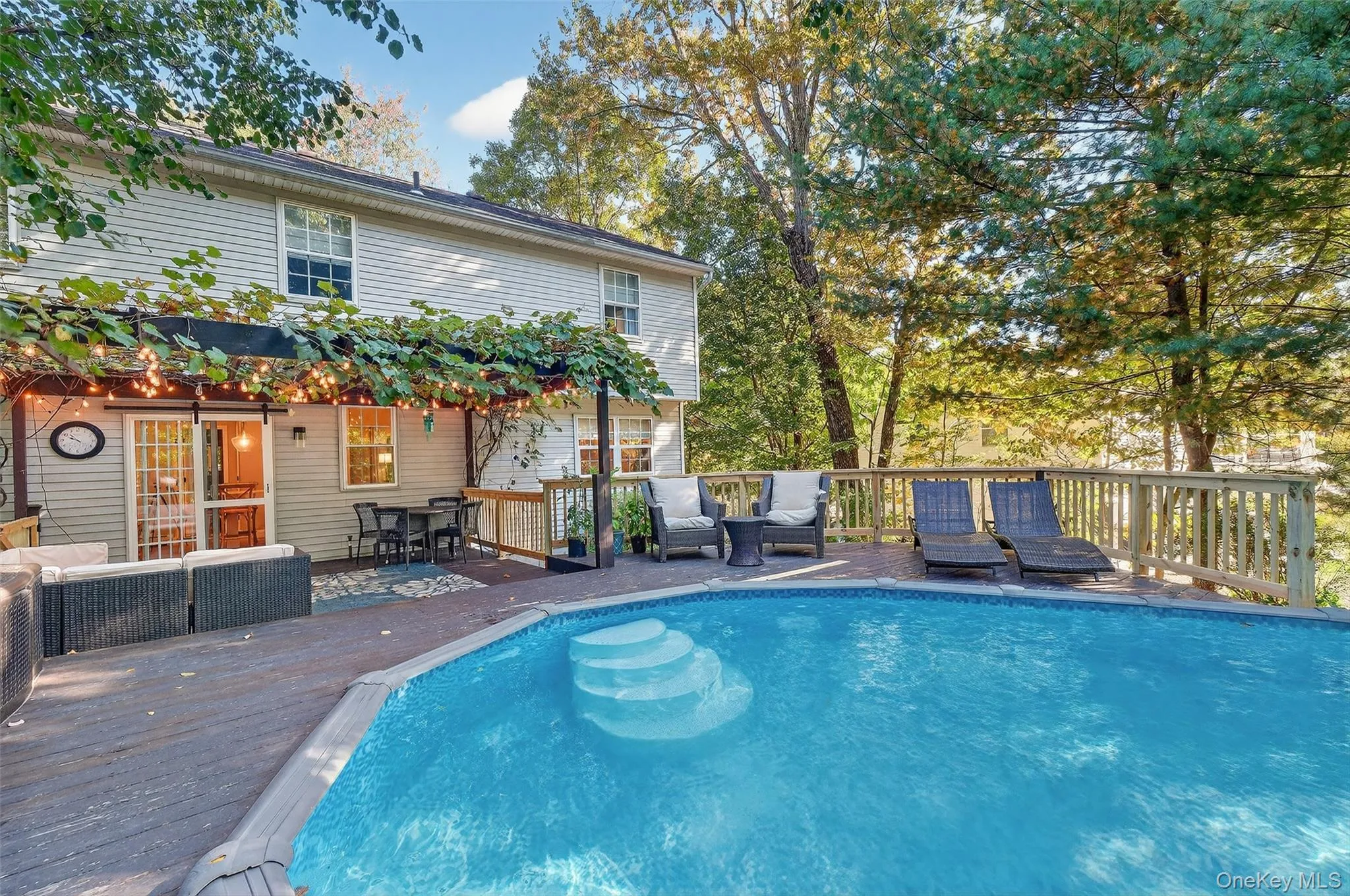 View of swimming pool with outdoor lounge area and a wooden deck View of swimming pool with outdoor lounge area and a wooden deck