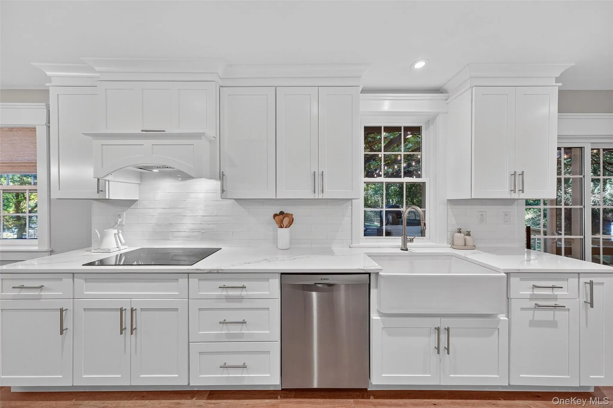 Kitchen featuring stainless steel dishwasher, white cabinets, light stone counters, tasteful backsplash, and recessed lighting Kitchen featuring stainless steel dishwasher, white cabinets, light stone counters, tasteful backsplash, and recessed lighting