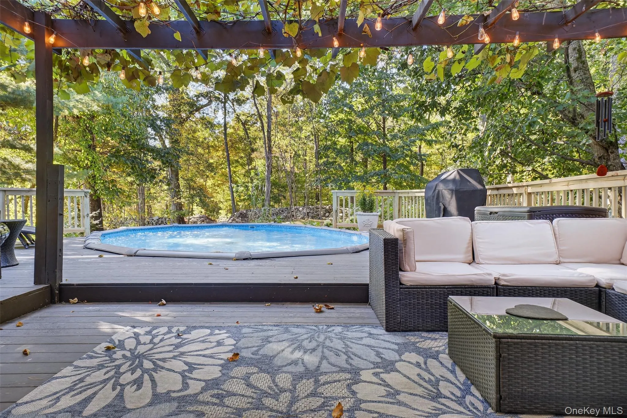 Wooden deck featuring an outdoor hangout area, an outdoor pool, and a grill Wooden deck featuring an outdoor hangout area, an outdoor pool, and a grill
