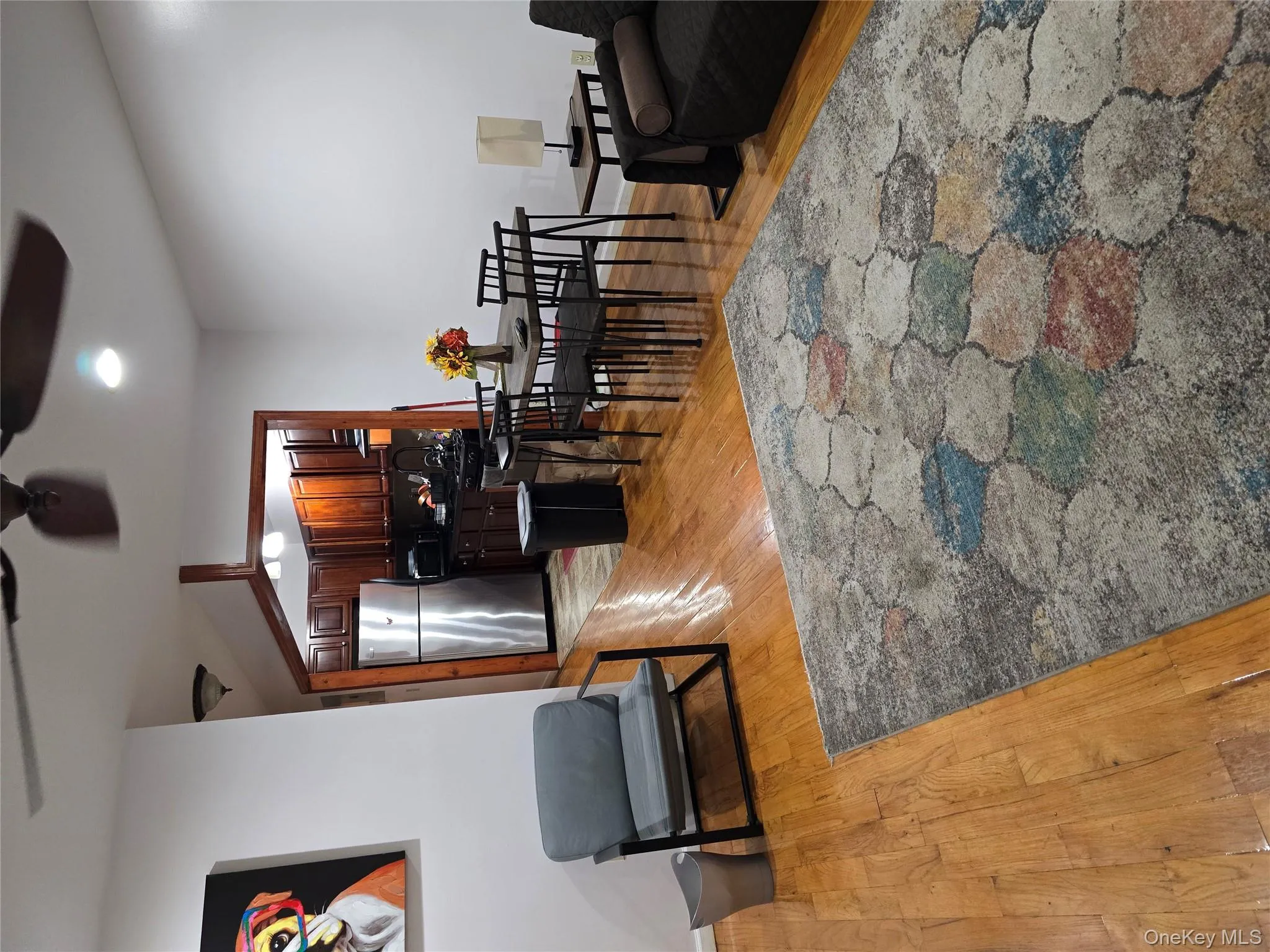 Living room featuring light wood-style flooring and a ceiling fan Living room featuring light wood-style flooring and a ceiling fan