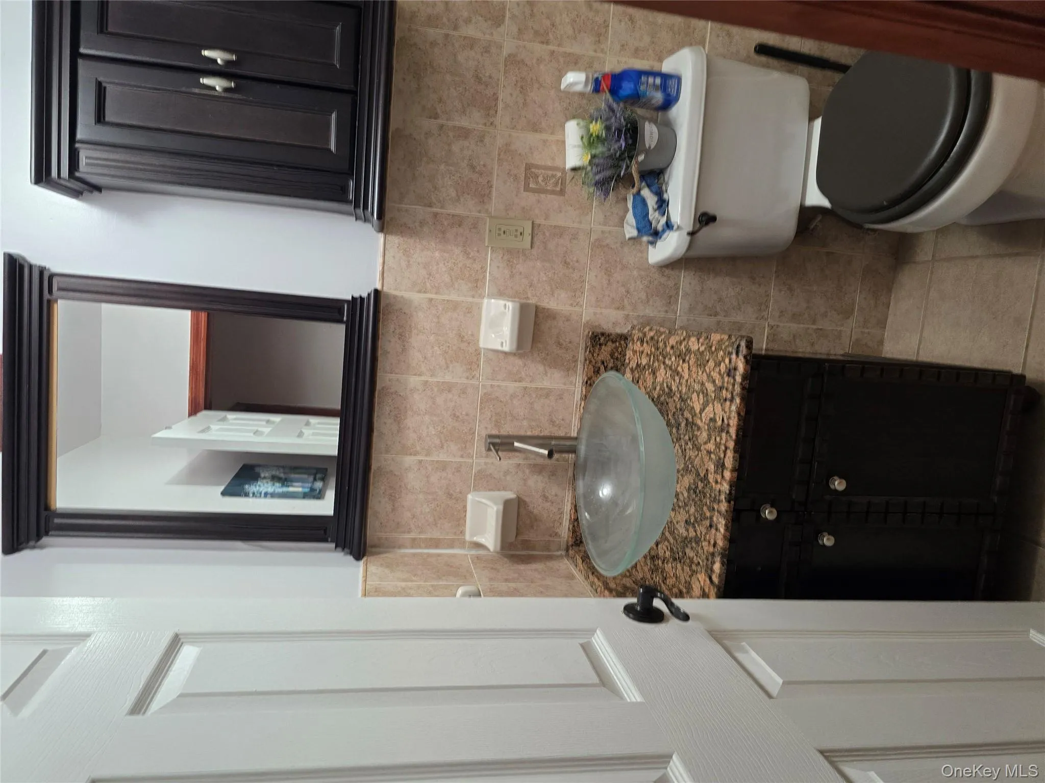 Bathroom featuring vanity, light tile patterned floors, and tile walls Bathroom featuring vanity, light tile patterned floors, and tile walls