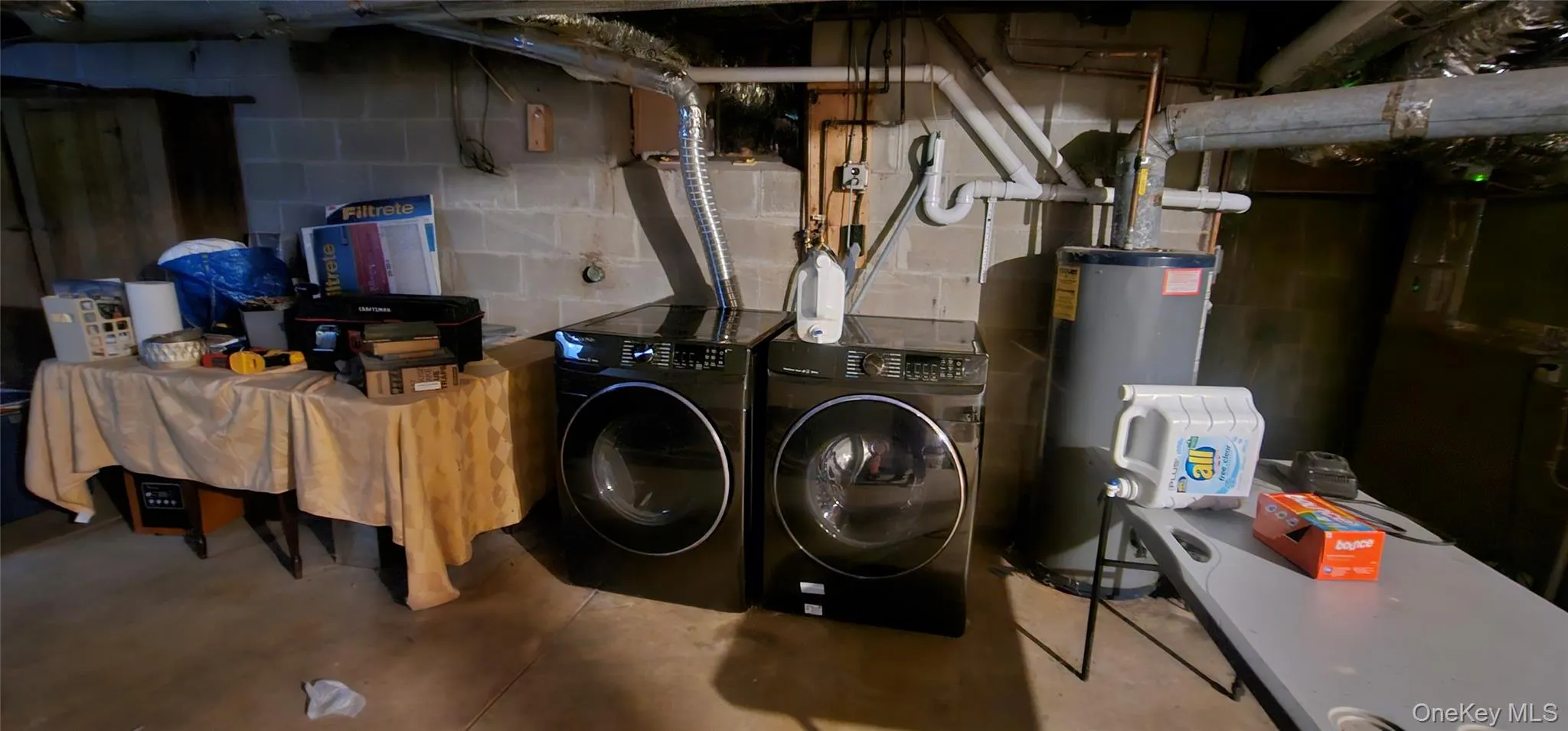 Unfinished below grade area with gas water heater and washer and clothes dryer Unfinished below grade area with gas water heater and washer and clothes dryer