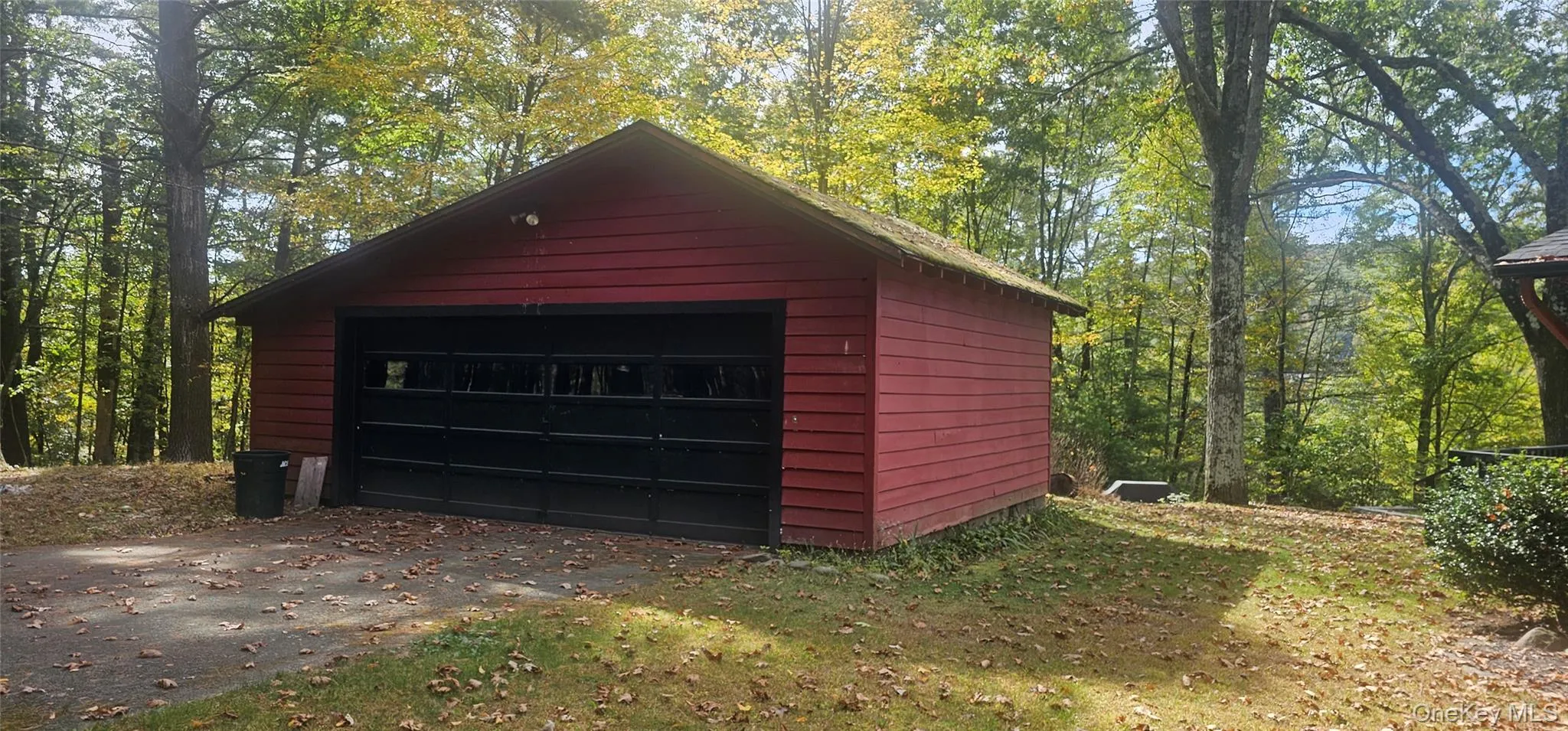 Detached garage featuring a view of trees Detached garage featuring a view of trees