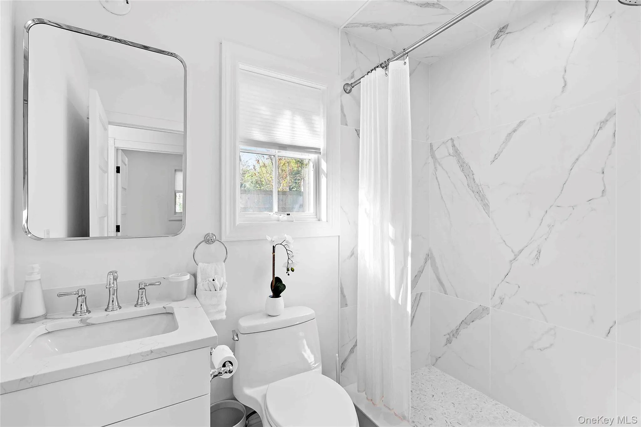 Bathroom featuring a marble finish shower and vanity Bathroom featuring a marble finish shower and vanity