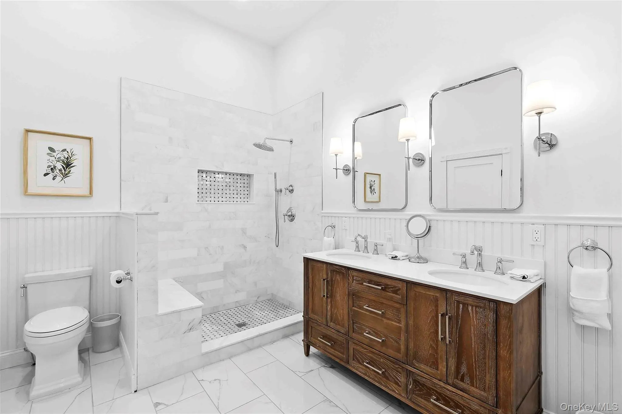 Bathroom featuring wainscoting, a walk in shower, double vanity, wooden walls, and light marble finish flooring Bathroom featuring wainscoting, a walk in shower, double vanity, wooden walls, and light marble finish flooring