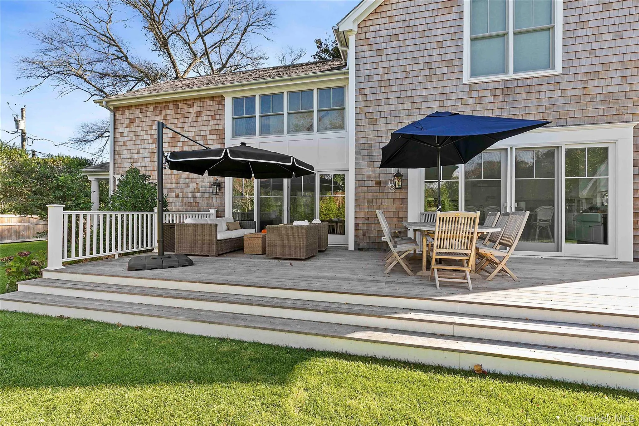 Back of house with a deck, outdoor dining area, and a lawn Back of house with a deck, outdoor dining area, and a lawn