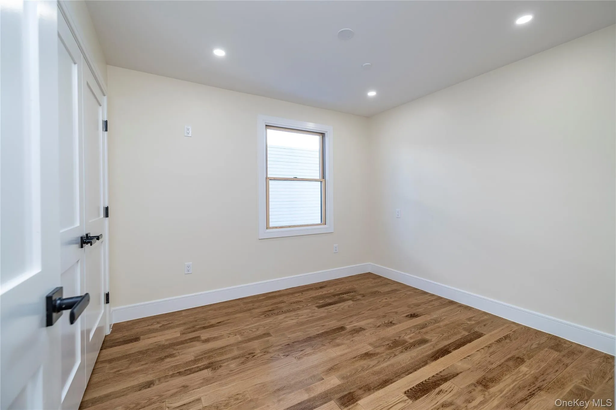 Empty room with wood finished floors and recessed lighting Empty room with wood finished floors and recessed lighting