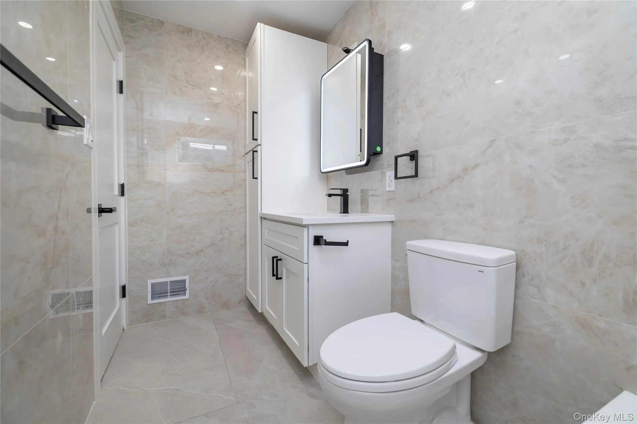 Bathroom featuring tile walls and vanity Bathroom featuring tile walls and vanity