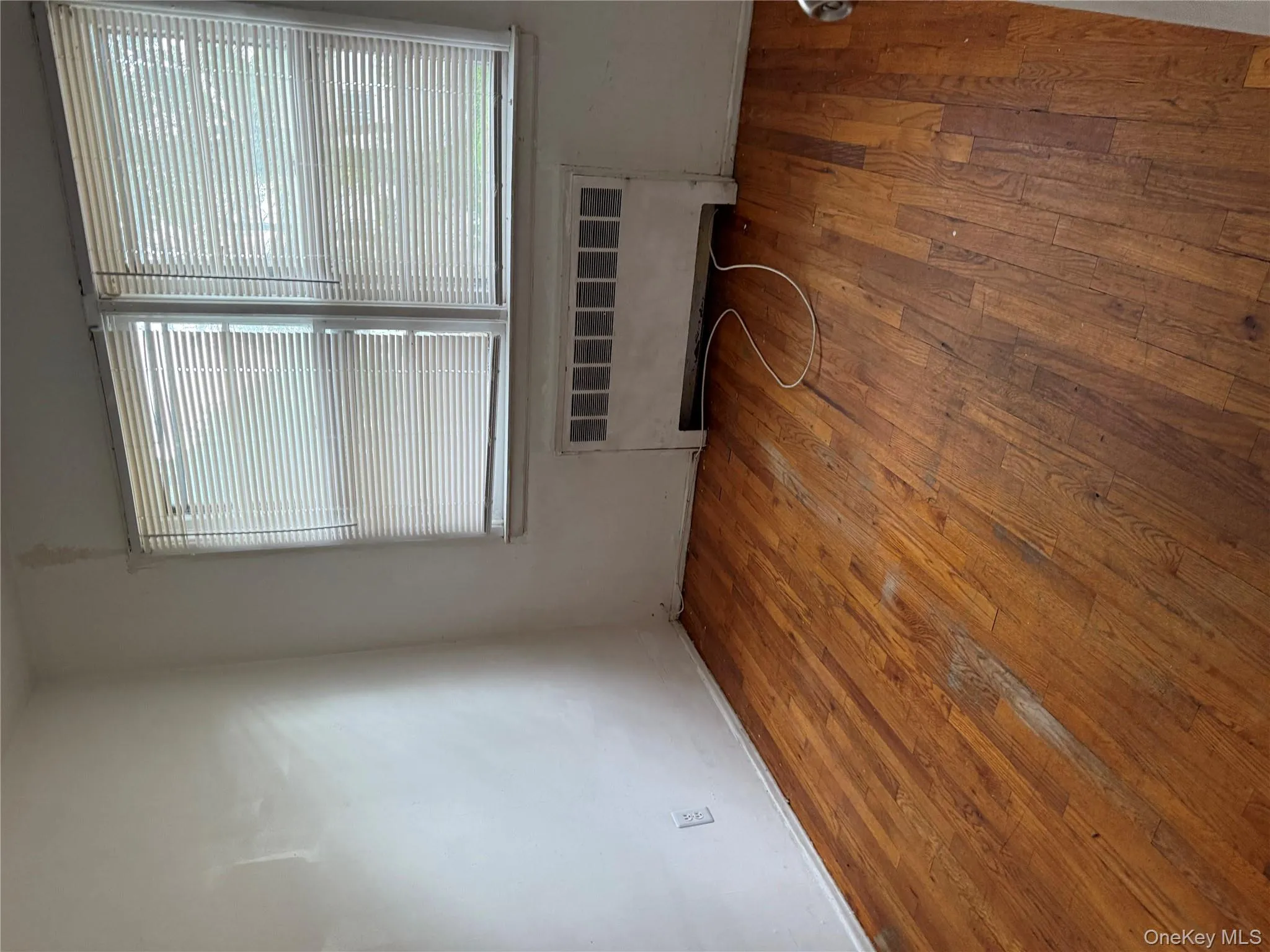 Empty room featuring radiator heating unit and light wood finished floors Empty room featuring radiator heating unit and light wood finished floors