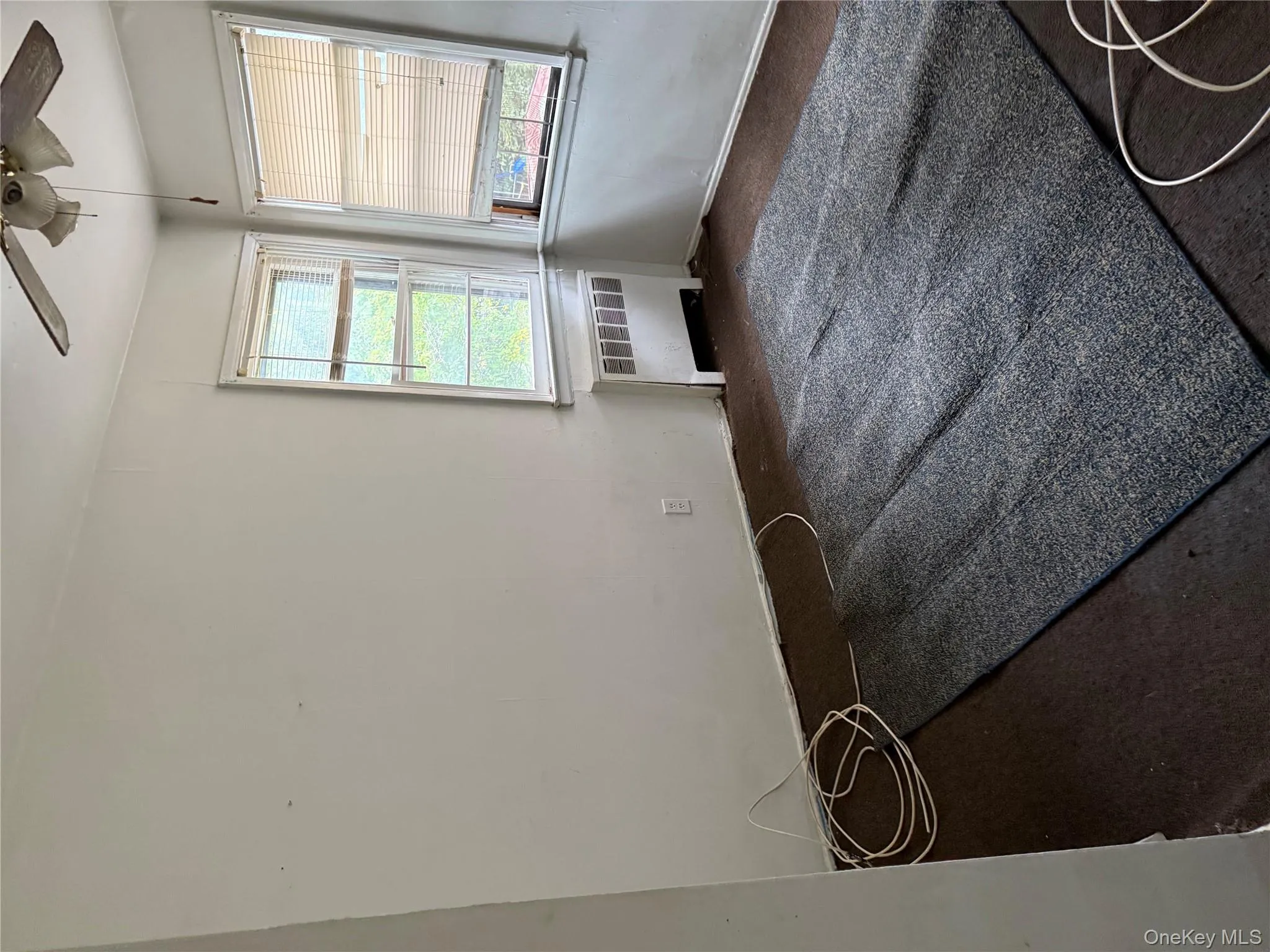 Unfurnished room featuring radiator heating unit and a ceiling fan Unfurnished room featuring radiator heating unit and a ceiling fan
