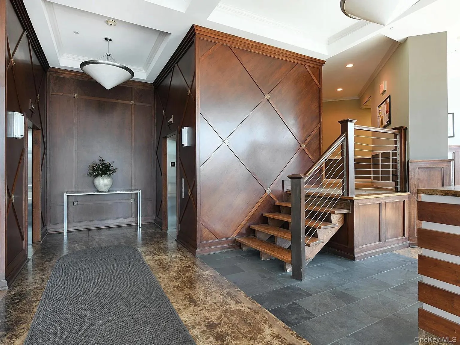 Stairway featuring ornamental molding and a decorative wall Stairway featuring ornamental molding and a decorative wall