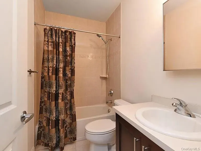 Full bathroom with vanity, shower / tub combo, and tile patterned floors Full bathroom with vanity, shower / tub combo, and tile patterned floors