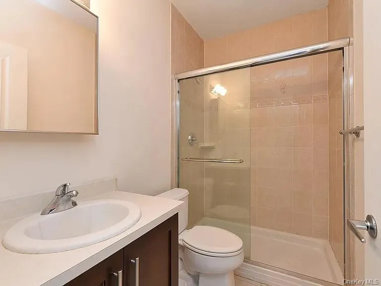 Bathroom featuring tiled shower and vanity Bathroom featuring tiled shower and vanity