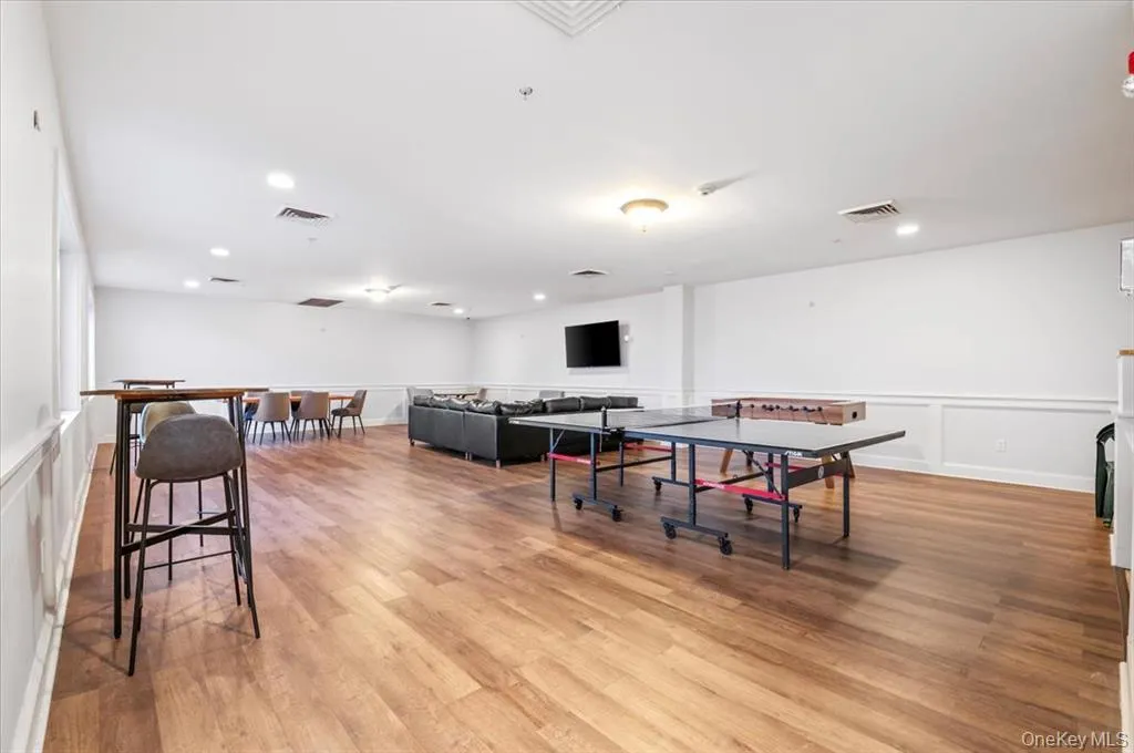 Playroom with a wainscoted wall, a decorative wall, light wood-style flooring, and recessed lighting Playroom with a wainscoted wall, a decorative wall, light wood-style flooring, and recessed lighting