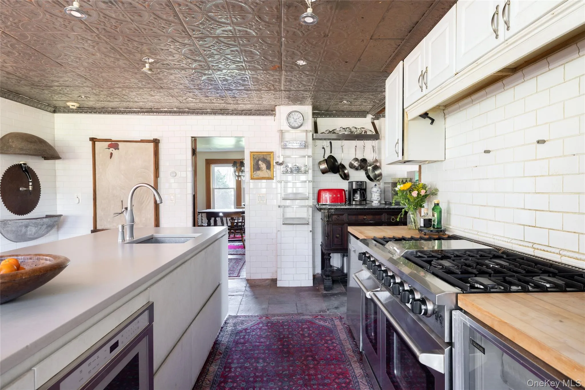 Kitchen featuring range with two ovens, white cabinets, and an ornate ceiling Kitchen featuring range with two ovens, white cabinets, and an ornate ceiling