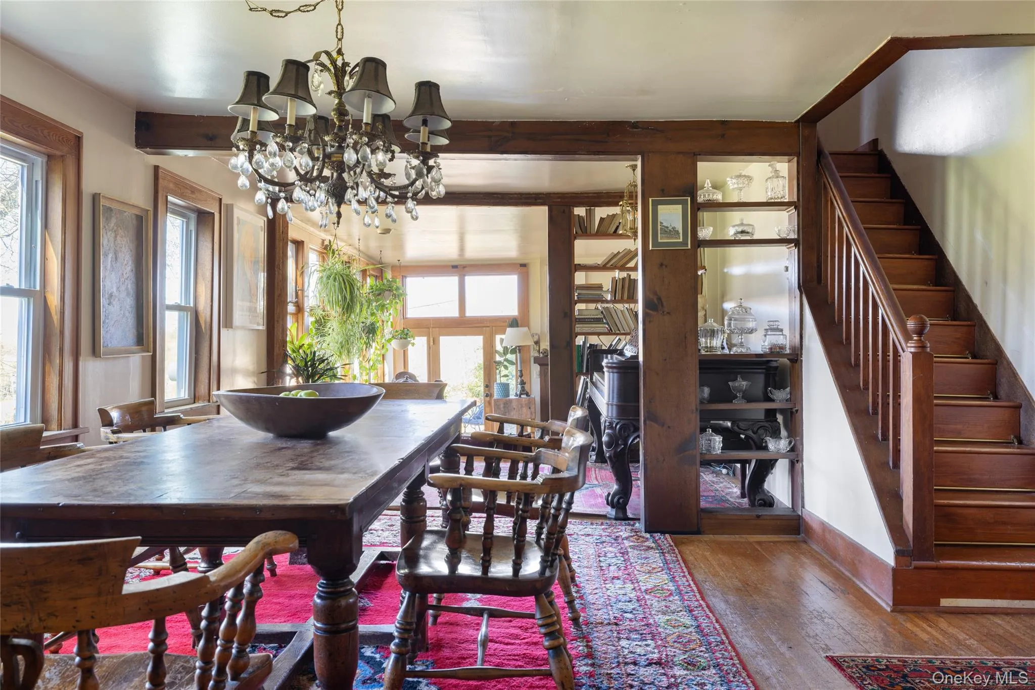 Dining area featuring stairway, wood flooring, beamed ceiling, and a chandelier Dining area featuring stairway, wood flooring, beamed ceiling, and a chandelier