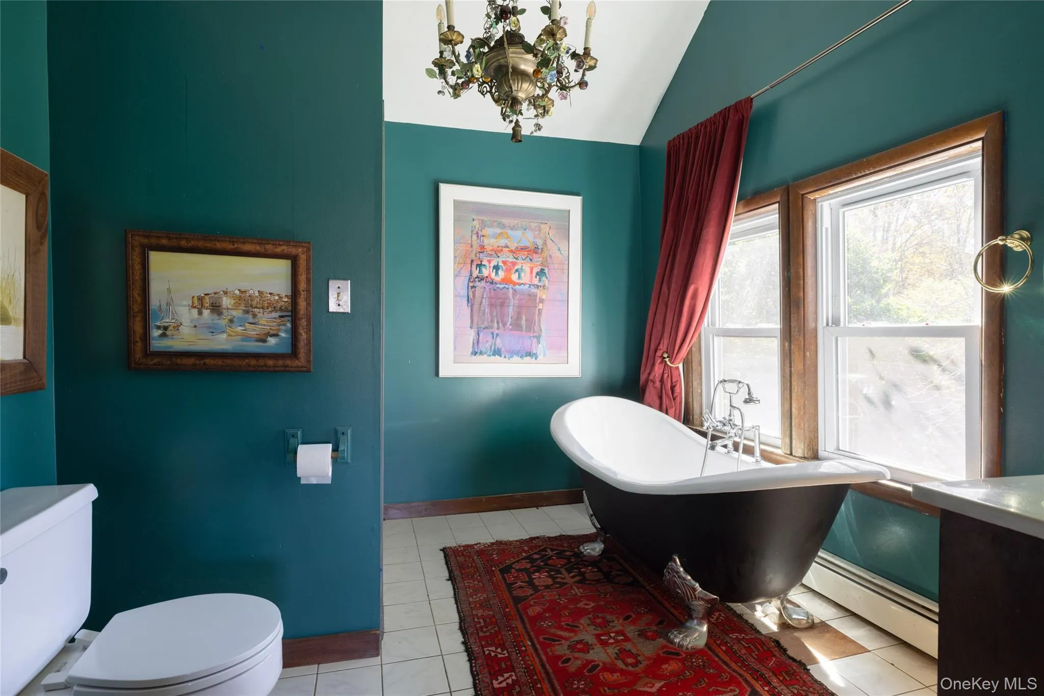 Primary bath featuring a soaking tub, baseboard heating, light tile patterned floors, a chandelier, and lofted ceiling Primary bath featuring a soaking tub, baseboard heating, light tile patterned floors, a chandelier, and lofted ceiling