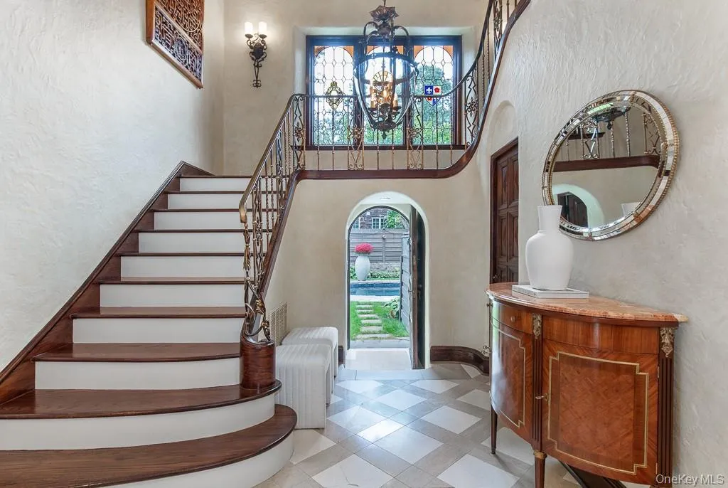 The elegant front-to-back formal entrance hall features a beautiful staircase with a windowed landing offering views of the pool and property, limestone floors, and archways leading to the formal living spaces. The entrance hall also features a door leading directly to the pool and backyard setting. There is also a powder room positioned discretely off the entrance hall. The elegant front-to-back formal entrance hall features a beautiful staircase with a windowed landing offering views of the pool and property, limestone floors, and archways leading to the formal living spaces. The entrance hall also features a door leading directly to the pool and backyard setting. There is also a powder room positioned discretely off the entrance hall.