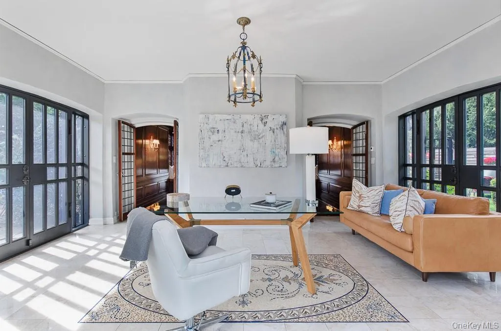 Office space featuring crown molding, plenty of natural light, french doors, a chandelier, and arched walkways Office space featuring crown molding, plenty of natural light, french doors, a chandelier, and arched walkways