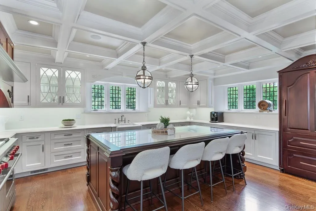 The luxurious gourmet chef's kitchen also features marble countertops, an oversized center island with seating, a coffered ceiling, top of the line appliances, and ample storage. The kitchen also opens to a breakfast area and family room. A door to the pool, property and outdoor cooking area is also located in the kitchen. The luxurious gourmet chef's kitchen also features marble countertops, an oversized center island with seating, a coffered ceiling, top of the line appliances, and ample storage. The kitchen also opens to a breakfast area and family room. A door to the pool, property and outdoor cooking area is also located in the kitchen.