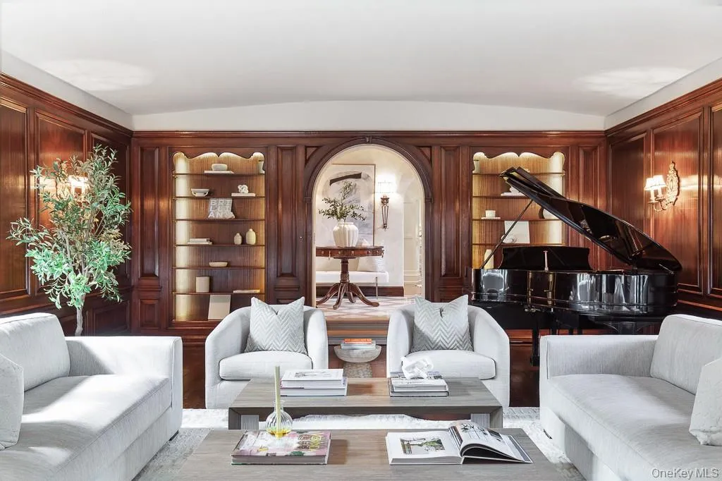 Alternative view of the formal living room showcases the Cuban mahogany wood paneling and custom built-in shelves with integrated lighting. Alternative view of the formal living room showcases the Cuban mahogany wood paneling and custom built-in shelves with integrated lighting.