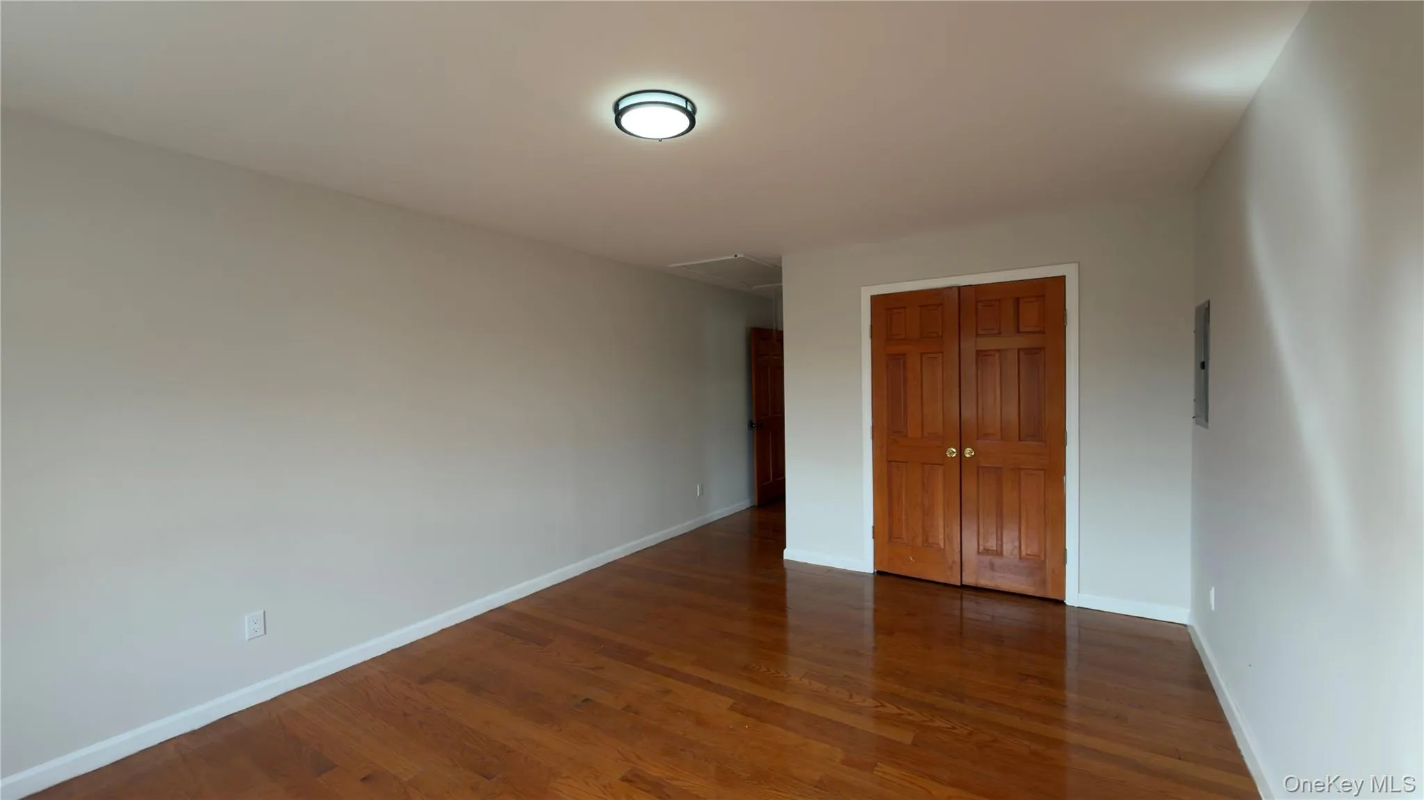 Unfurnished bedroom featuring dark wood-style flooring and a closet Unfurnished bedroom featuring dark wood-style flooring and a closet