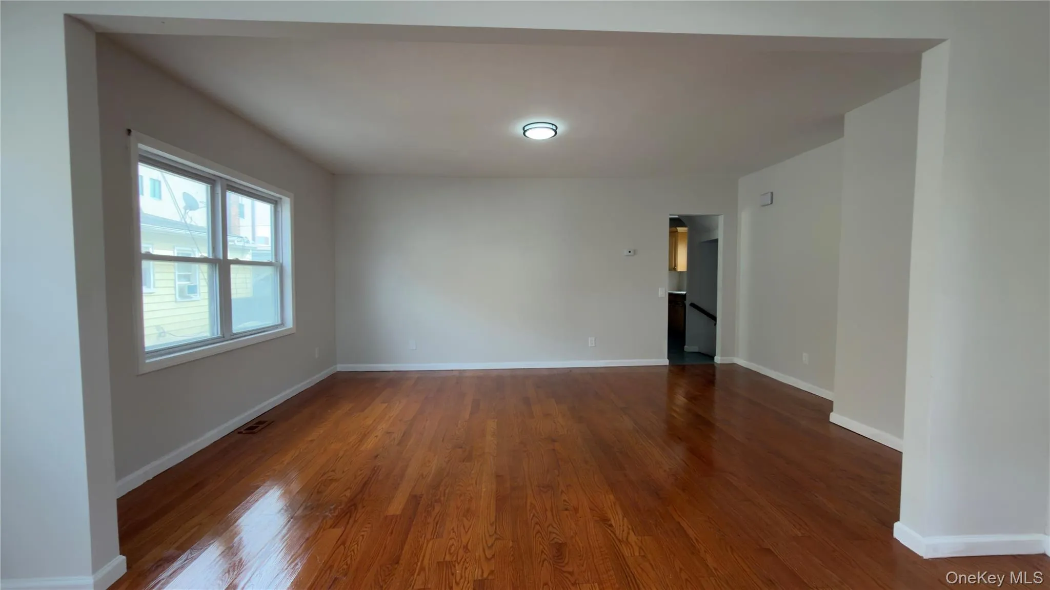 Unfurnished room with dark wood-style floors and baseboards Unfurnished room with dark wood-style floors and baseboards