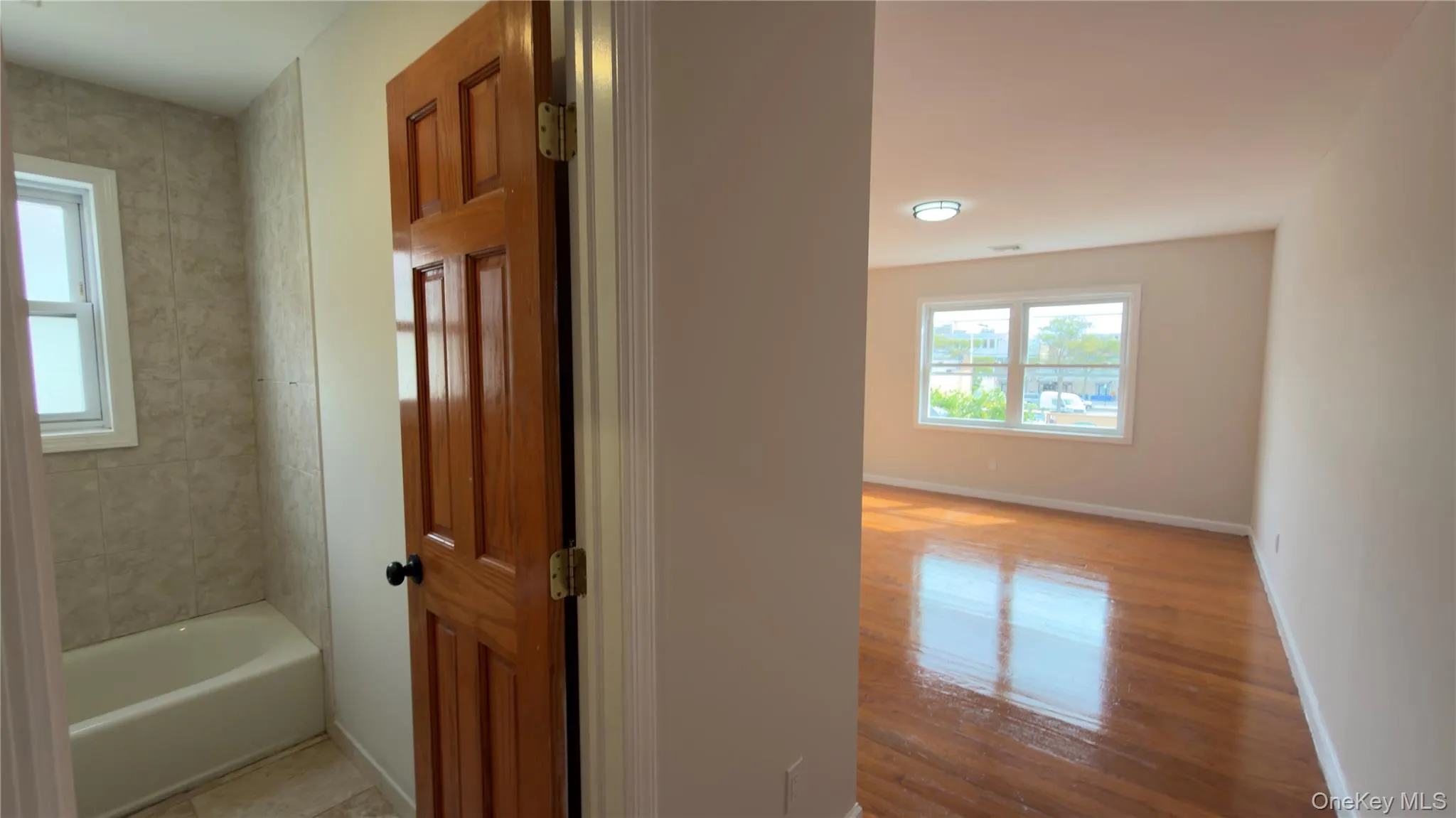 Hall featuring baseboards and light wood-style floors Hall featuring baseboards and light wood-style floors