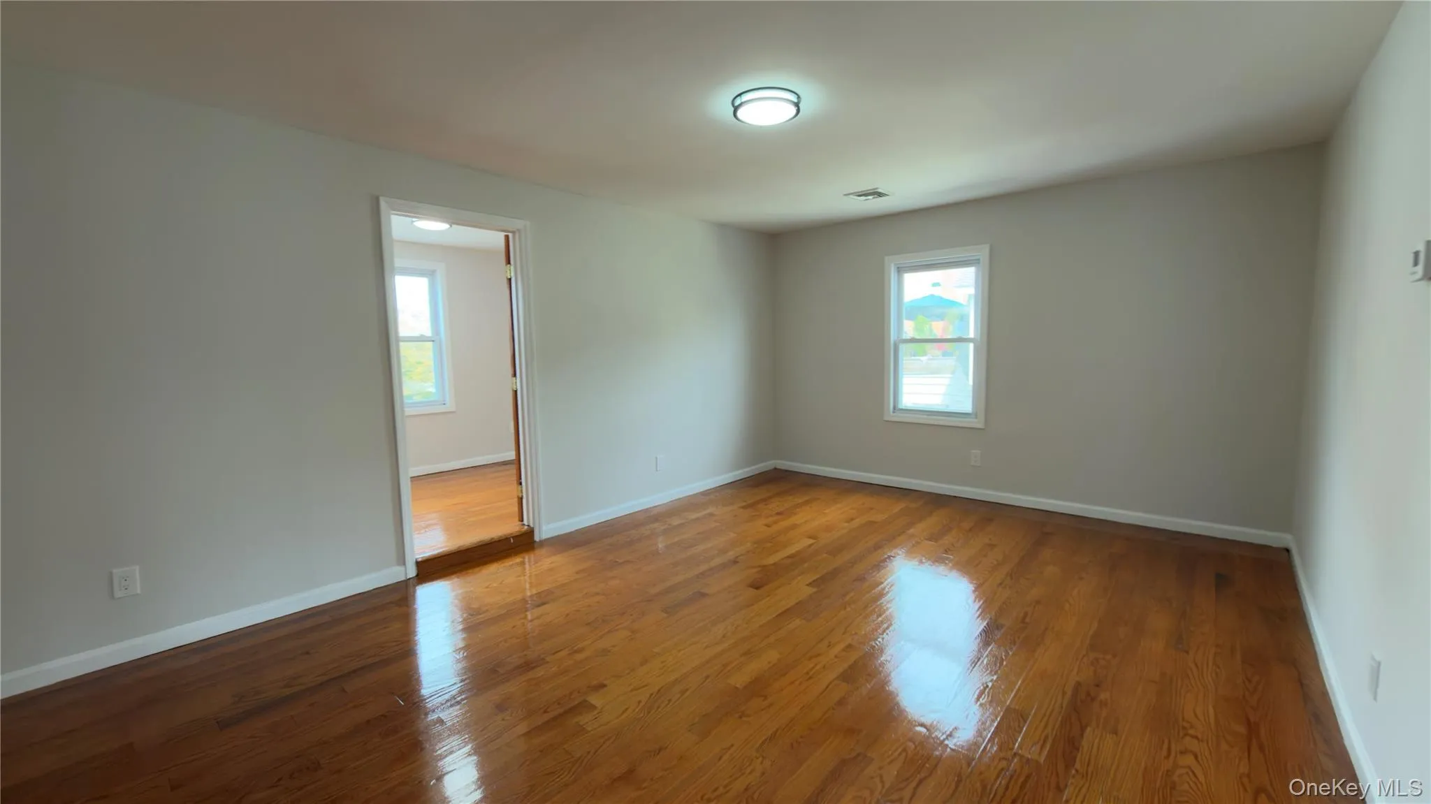 Empty room with wood finished floors and baseboards Empty room with wood finished floors and baseboards