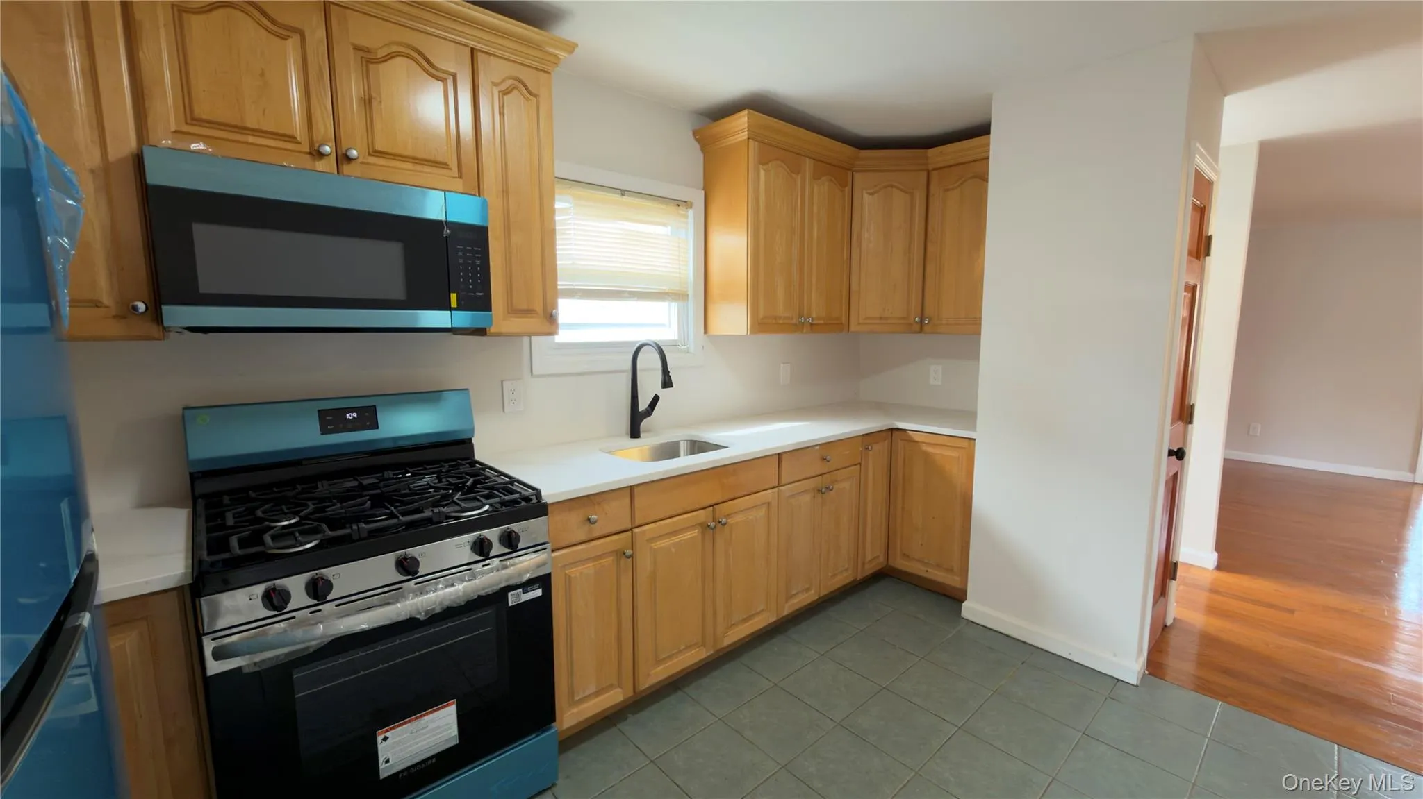 Kitchen with appliances with stainless steel finishes and dark tile patterned floors Kitchen with appliances with stainless steel finishes and dark tile patterned floors