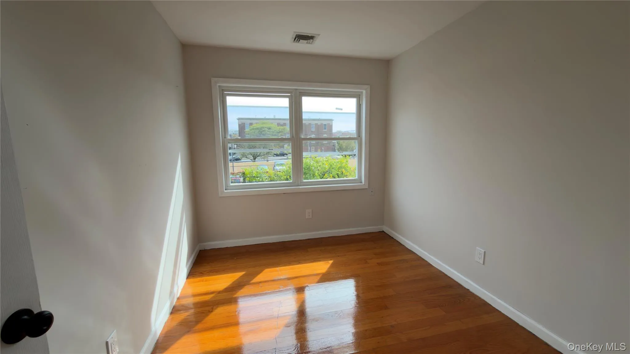 Spare room featuring baseboards and light wood finished floors Spare room featuring baseboards and light wood finished floors
