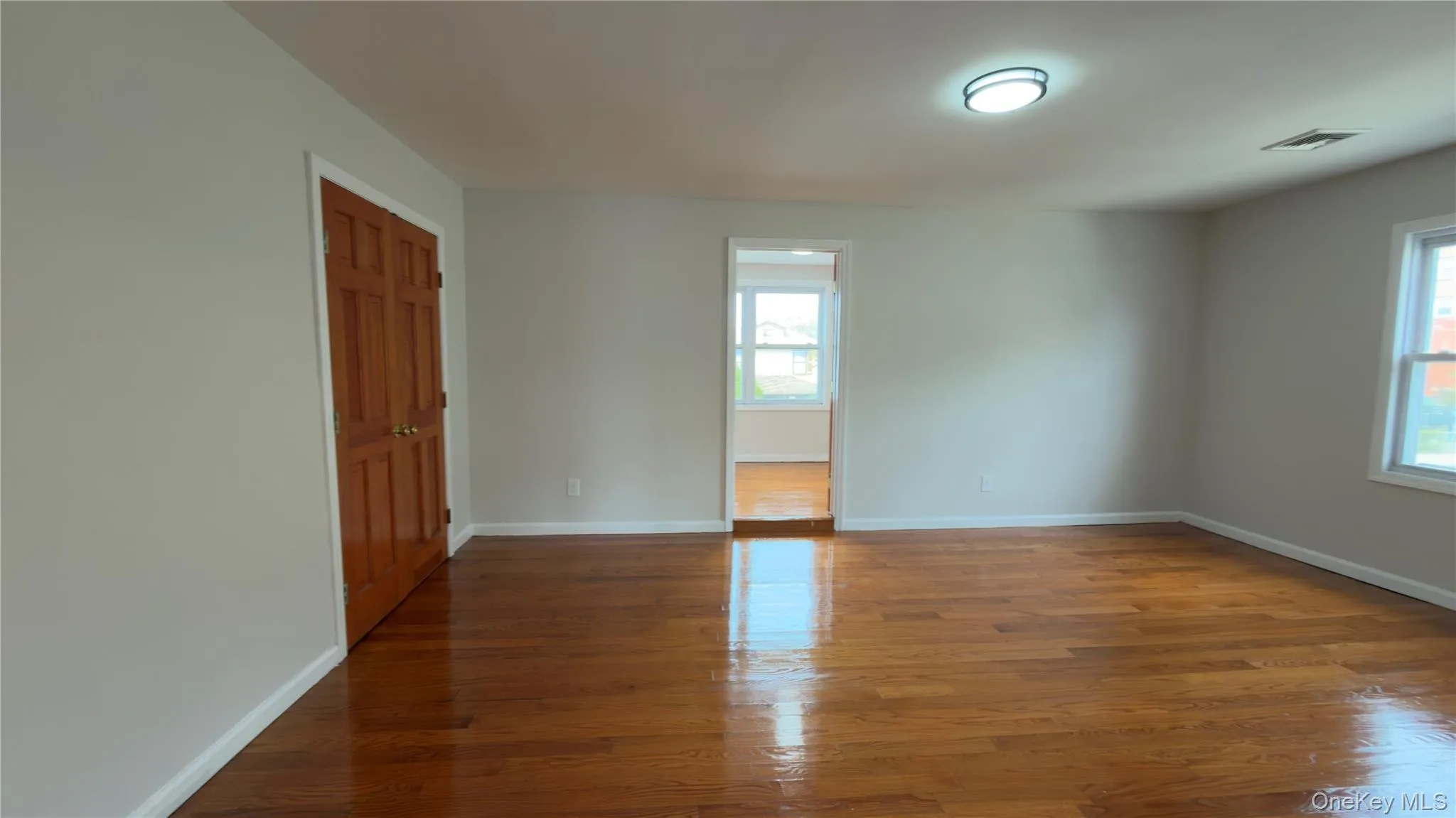 Empty room with wood finished floors and baseboards Empty room with wood finished floors and baseboards