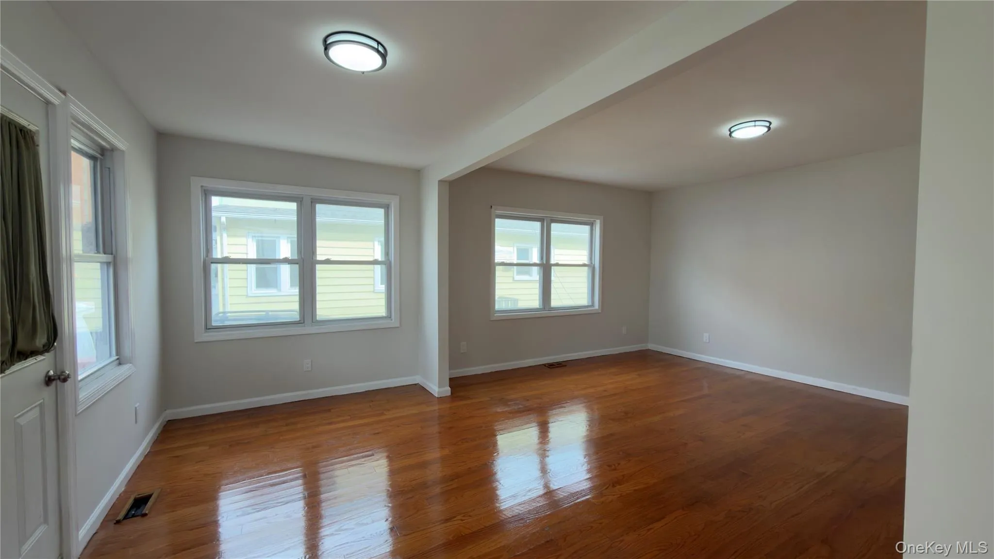 Unfurnished room with wood finished floors and baseboards Unfurnished room with wood finished floors and baseboards