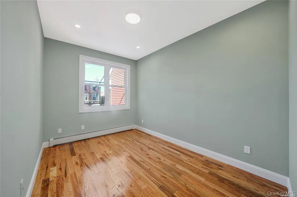 Empty room featuring a baseboard radiator, light wood-style flooring, and recessed lighting Empty room featuring a baseboard radiator, light wood-style flooring, and recessed lighting