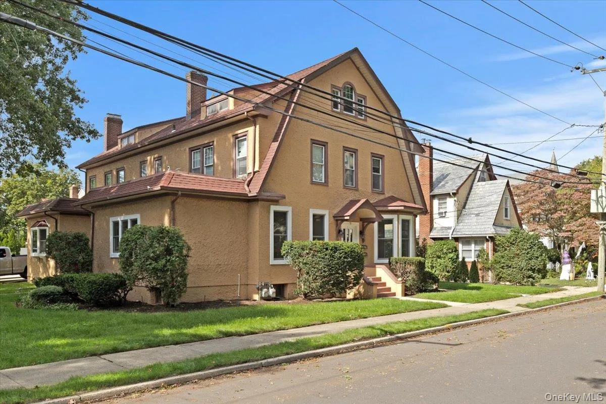 View of front facade featuring stucco siding, a chimney, and a front lawn View of front facade featuring stucco siding, a chimney, and a front lawn