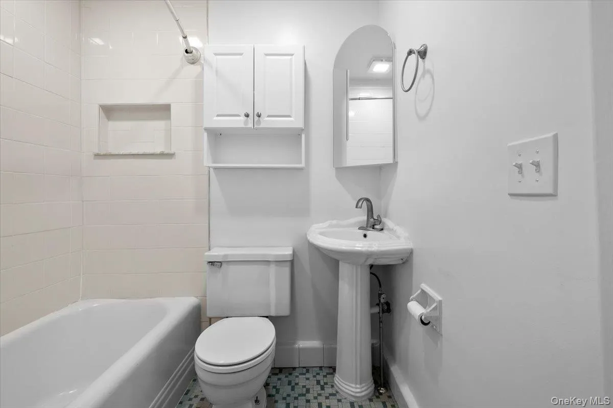 Bathroom with shower / tub combination and tile patterned flooring Bathroom with shower / tub combination and tile patterned flooring