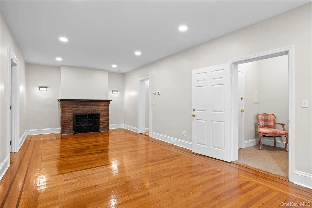 Unfurnished living room with light wood-type flooring, a fireplace, and recessed lighting Unfurnished living room with light wood-type flooring, a fireplace, and recessed lighting