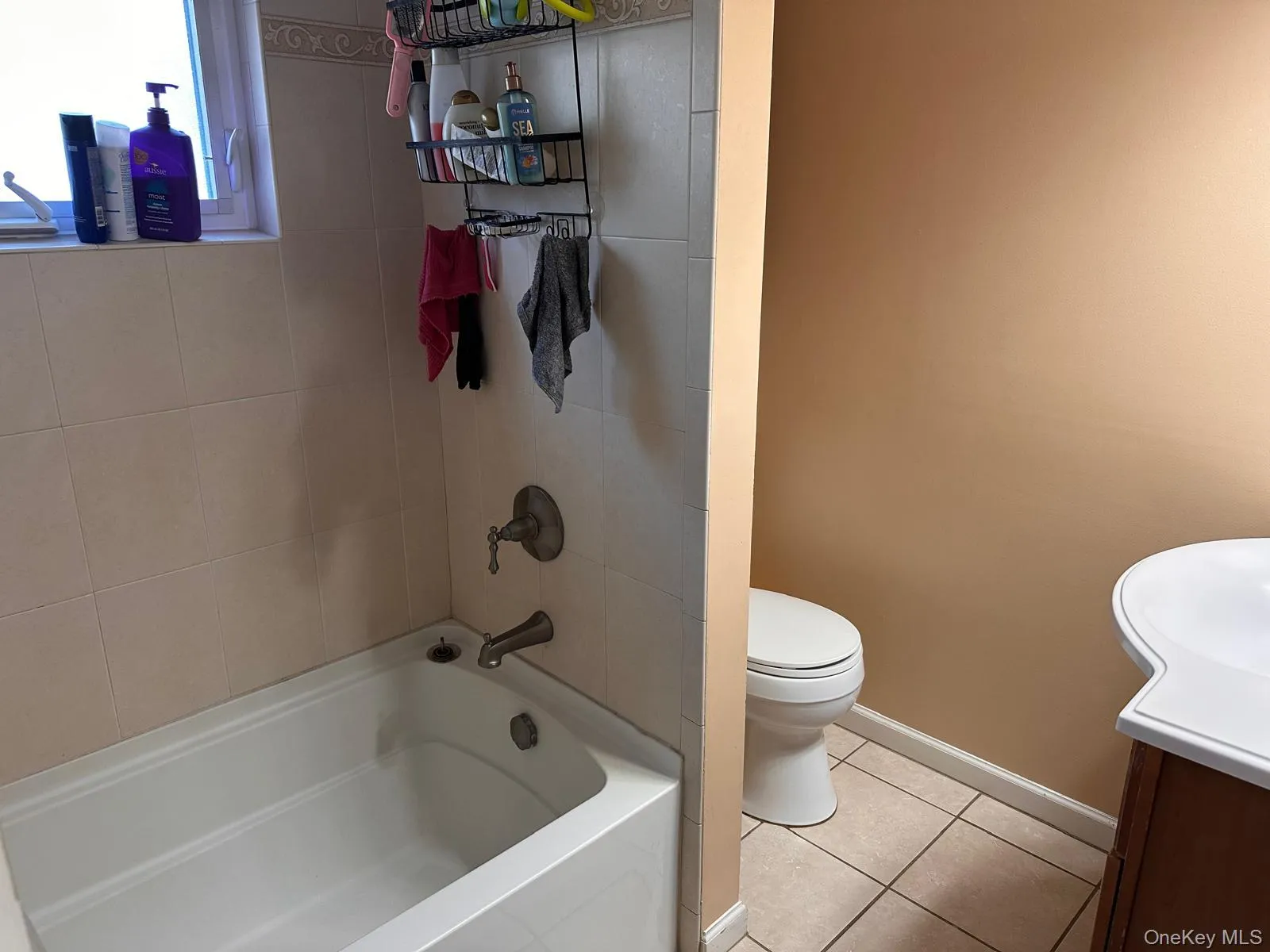 Full bathroom with vanity, light tile patterned floors, and bathing tub / shower combination Full bathroom with vanity, light tile patterned floors, and bathing tub / shower combination